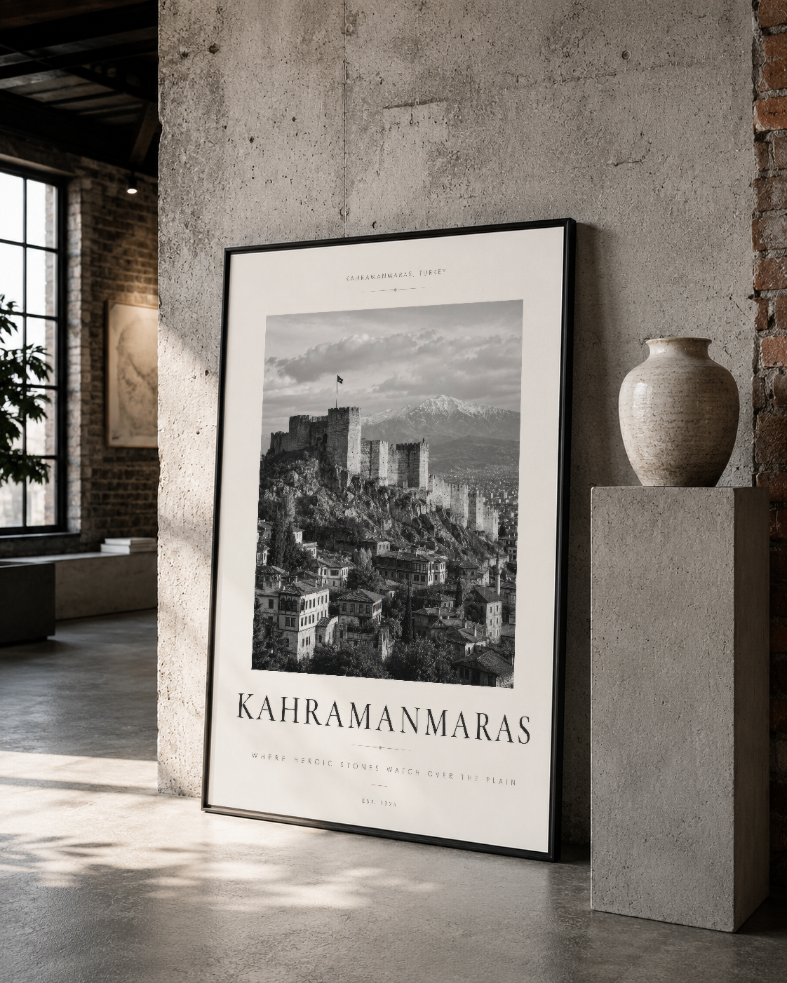 Siyah çerçeveli Kahraman Maraş şehir fotoğrafı posteri, modern loft ortamında sergileniyor.
