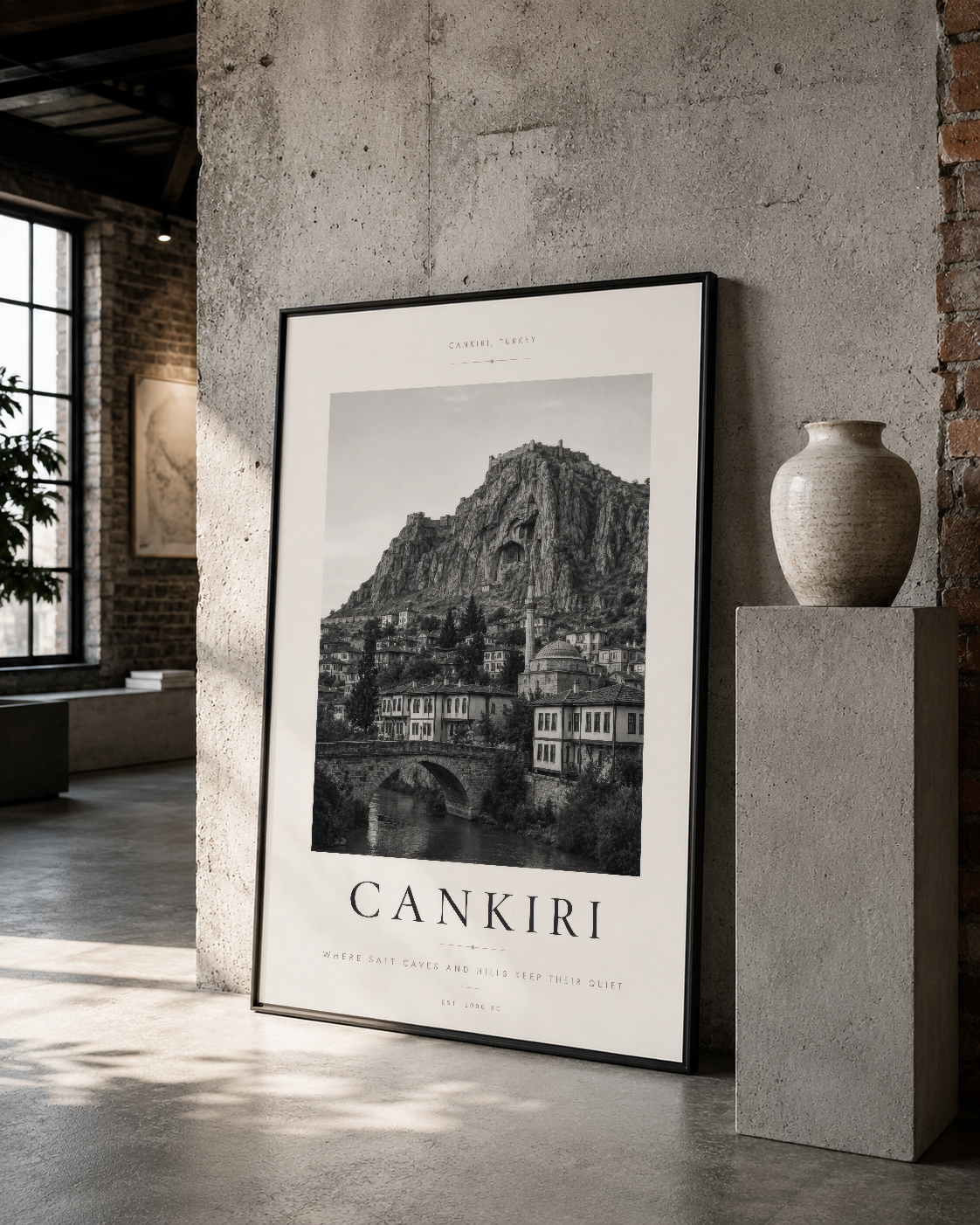 Siyah çerçeveli Çankırı tablosu endüstriyel mekanda, atmosferik ışıkta duruyor.