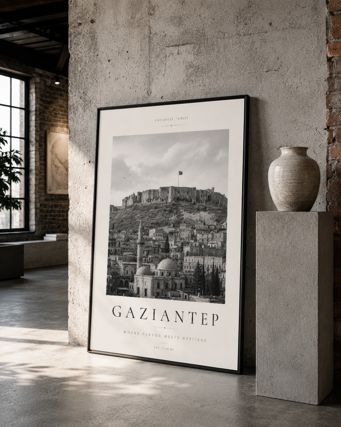 Gaziantep panoramasının dramatik siyah beyaz görüntüsü, kalın siyah çerçevede dönem yapısıyla uyumlu bir galeri alanında yer