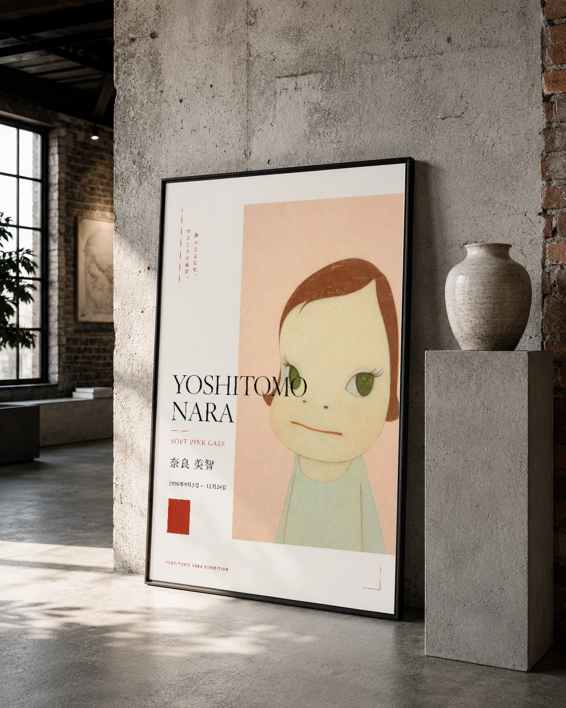 Siyah çerçeveli sanat eseri, karakteristik çocuksu yüz tasarımı, loft stilinde beton duvar ortamında sergileniyor.