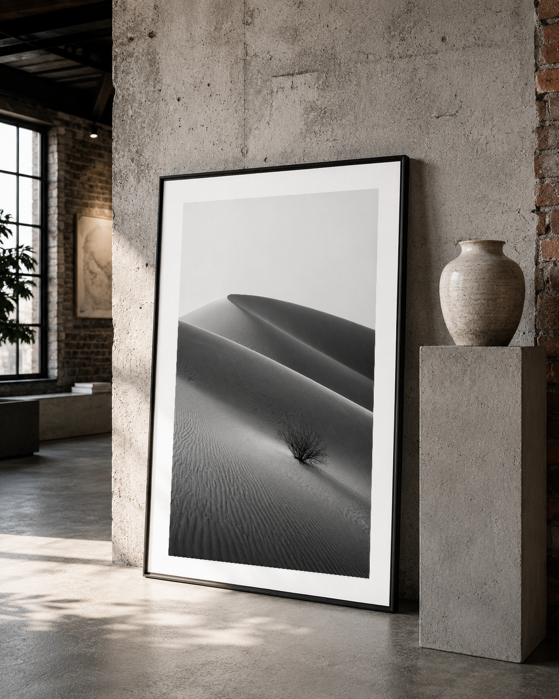 Siyah çerçeveli çöl dünü fotoğrafı, brutalist iç mimaride sanat nesnesi olarak sunuluyor.