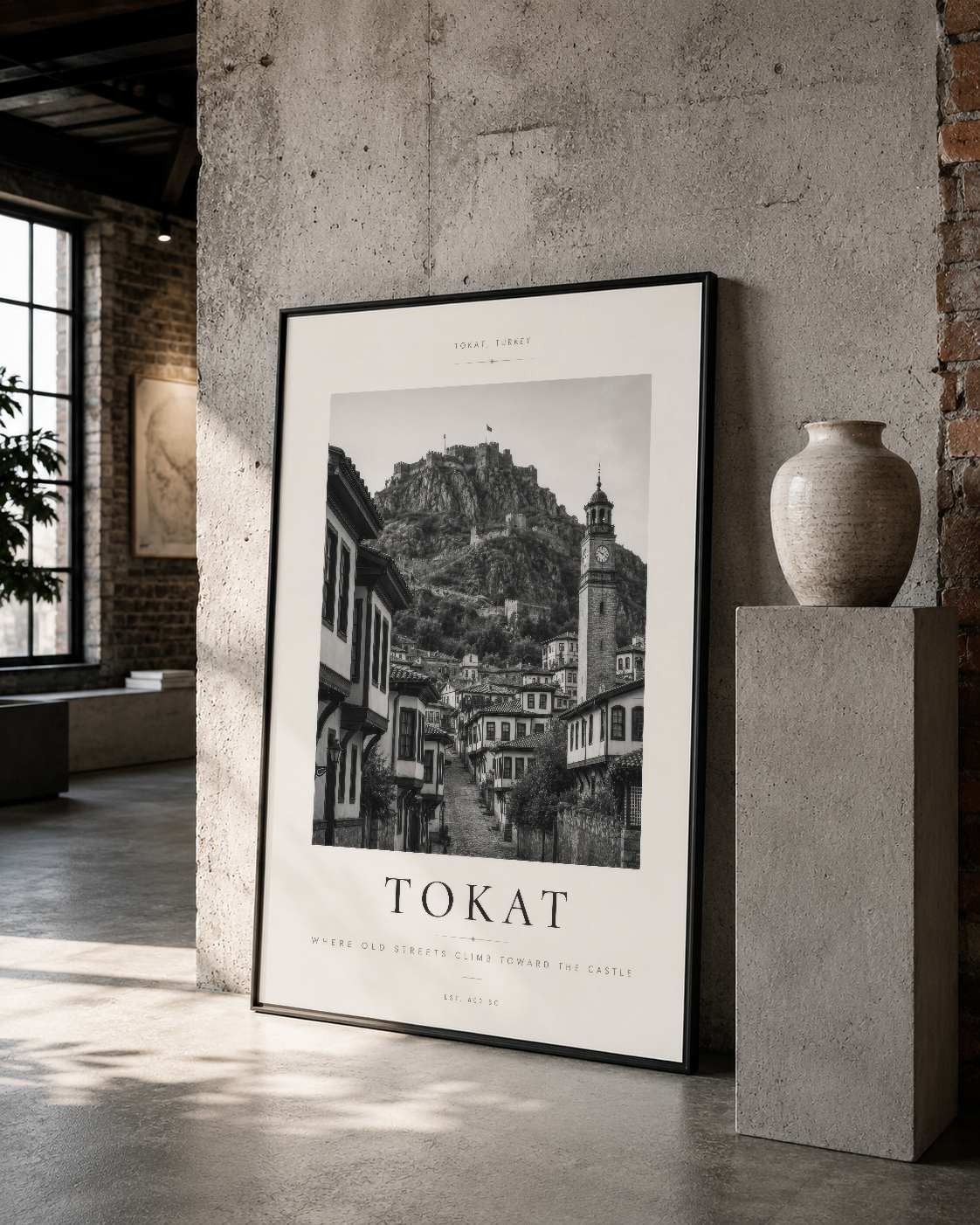 Tokat'ın tarihi sokak dokusunu yansıtan klasik siyah beyaz baskı, siyah çerçevede loft stil iç mekanda konumlandırılmış.