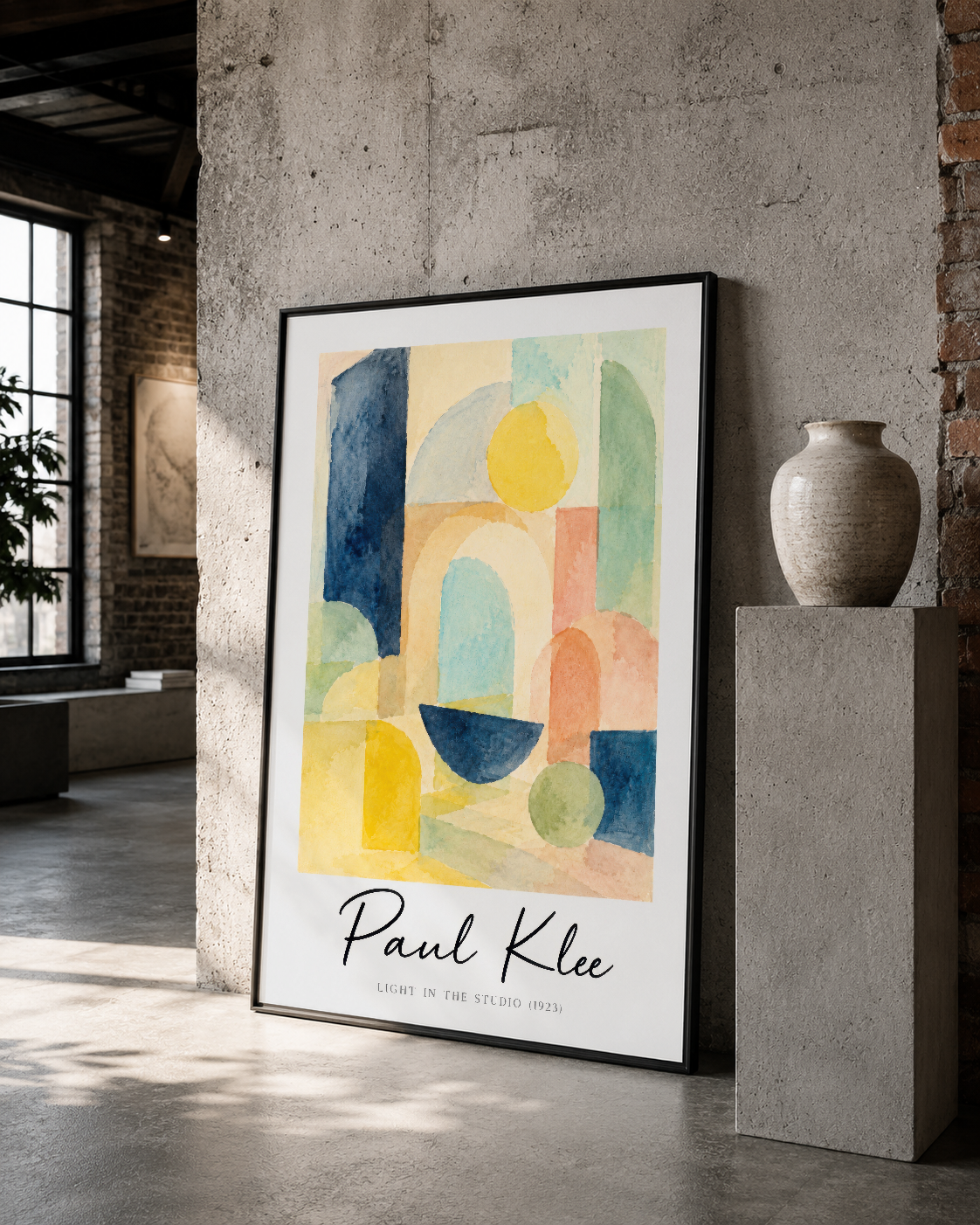 Pastel renkli geometrik desen içeren Paul Klee tablosu, siyah çerçevesiyle betonlu minimalist ortamda sergileniyor.