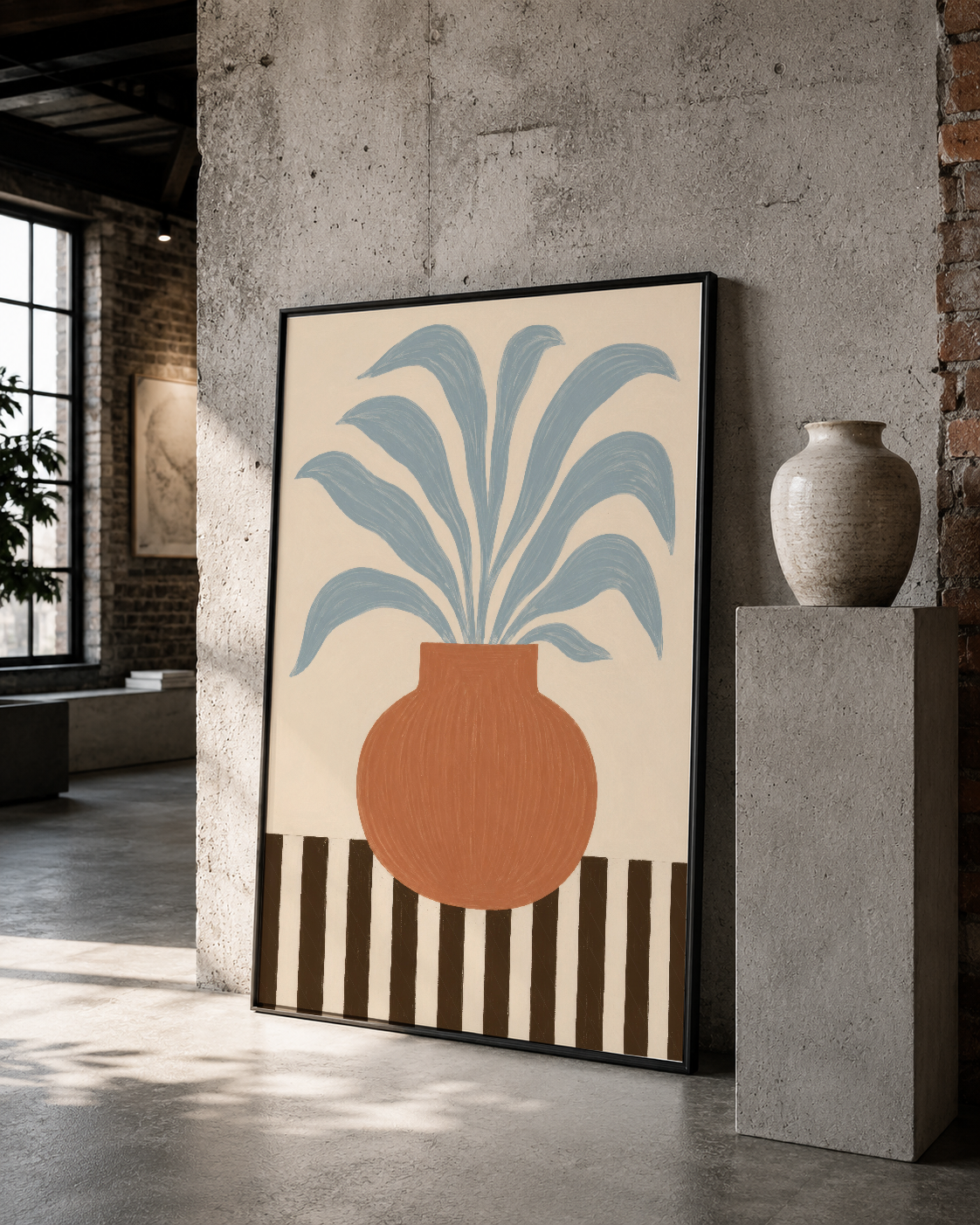 Geometrik desenli saksı ve mavi yaprakları betimleyen çerçeveli sanat eseri, minimalist loft ortamında.
