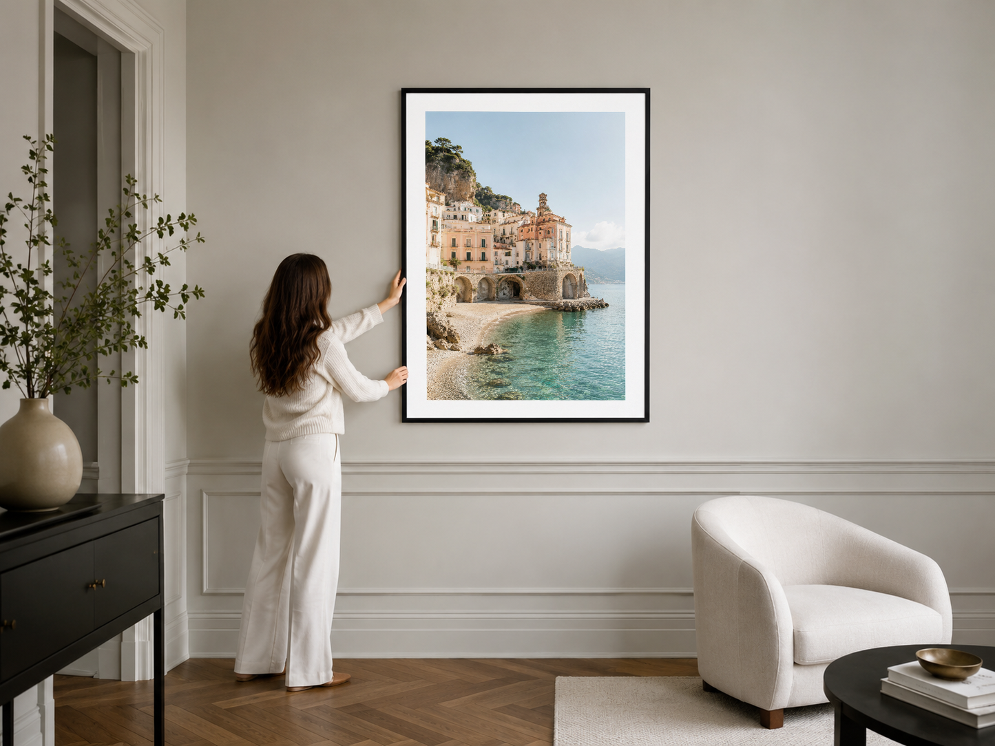 Turkuaz deniz ve sarı binalarla Amalfi'yi gösteren siyah çerçeveli poster, şık iç tasarımda asılı.