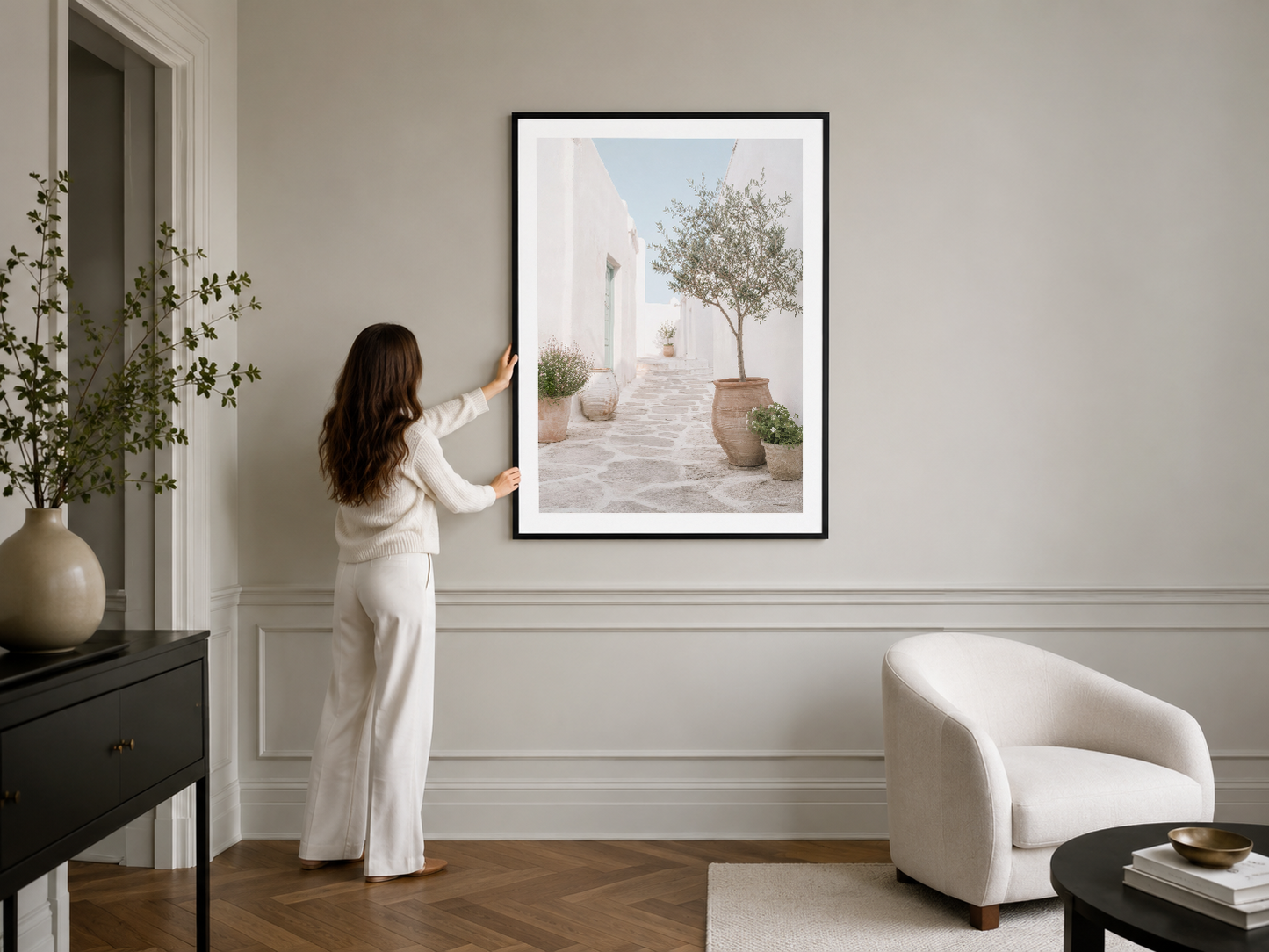 Seramik saksı ve şık mobilya ile tamamlanan siyah çerçeveli modern yaşam alanı duvar sanat koleksiyonu.