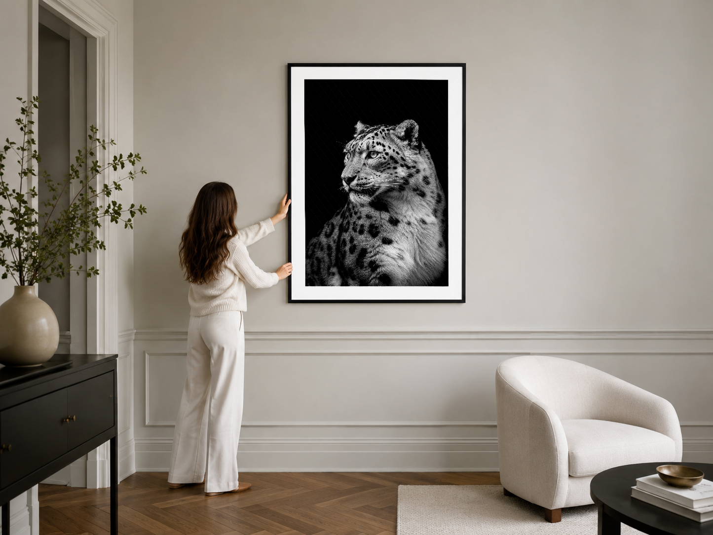 Siyah çerçeveli leopar portresi, minimalist odasının duvarında sanatsal aksan oluşturuyor.