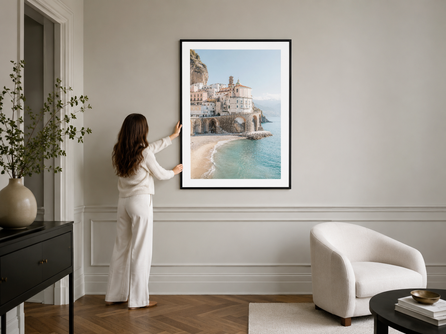 Sahil şehir manzarası sunan elegante siyah çerçeveli poster, klasik beyaz duvarda asılı.