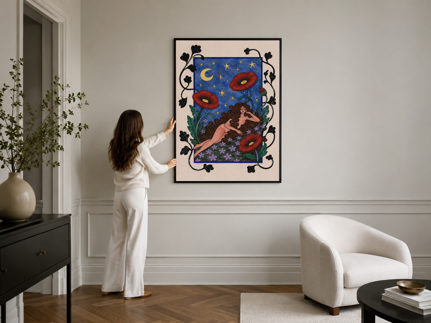 Modern iç mekanında, siyah çerçeveli dekoratif tablo; gece gökyüzü, çiçekler ve sensual figürü sunan sanat eseri.