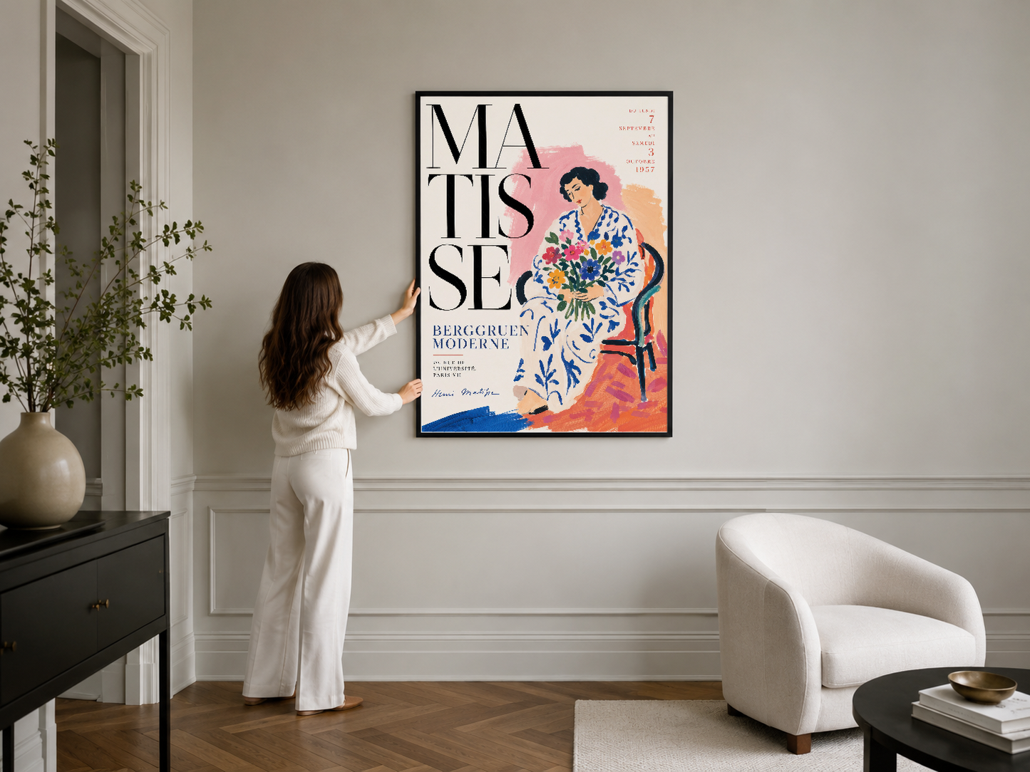 Matisse tasarımı siyah çerçeveli poster, şık bir iç mekanda beyaz bok sandalyesi yanında duvarda konumlanmış.