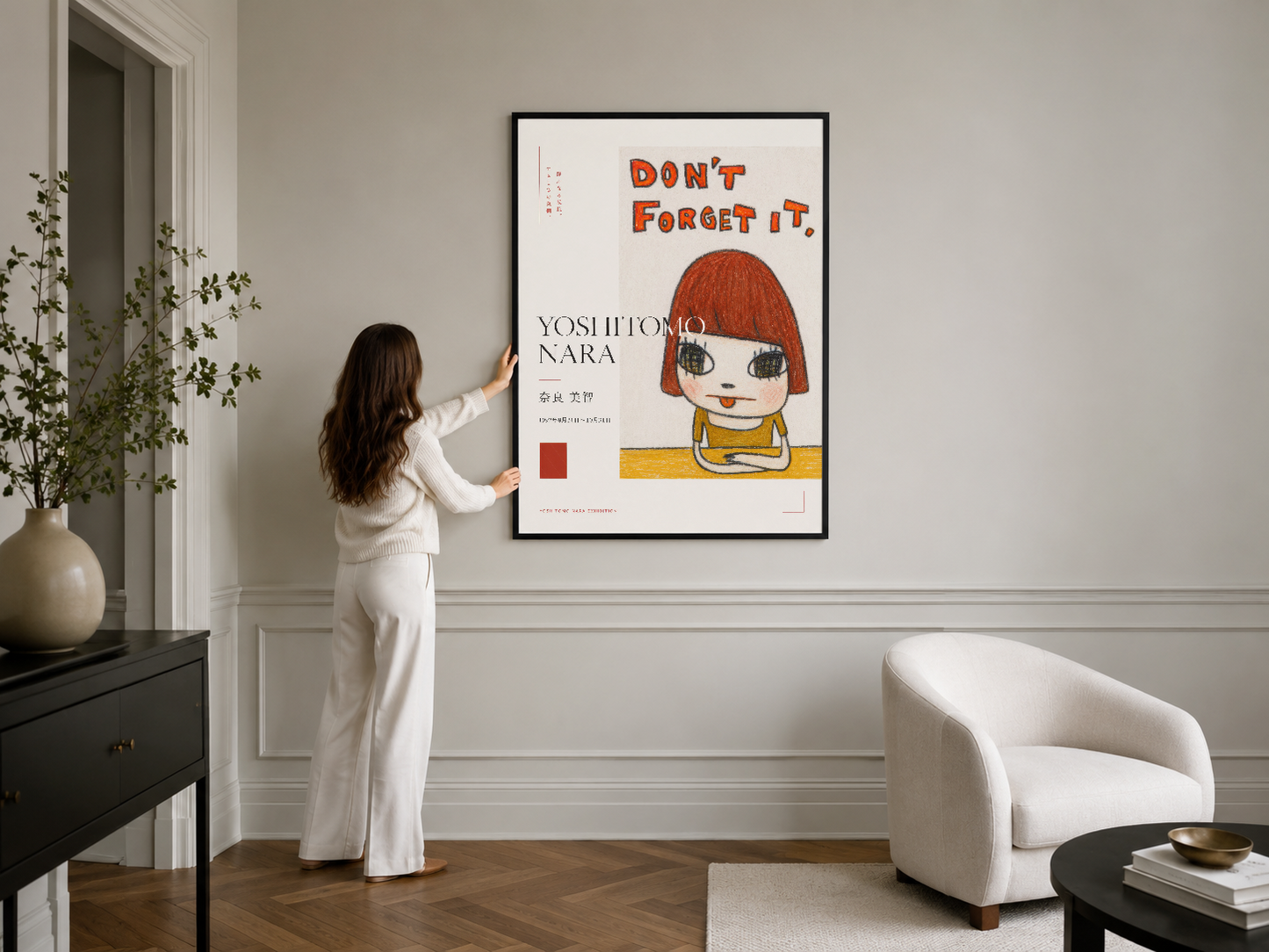 Siyah çerçeveli Yoshitomo Nara posteri, şık modern odada duvar dekorasyon aksesuarı olarak konumlandırılmış.