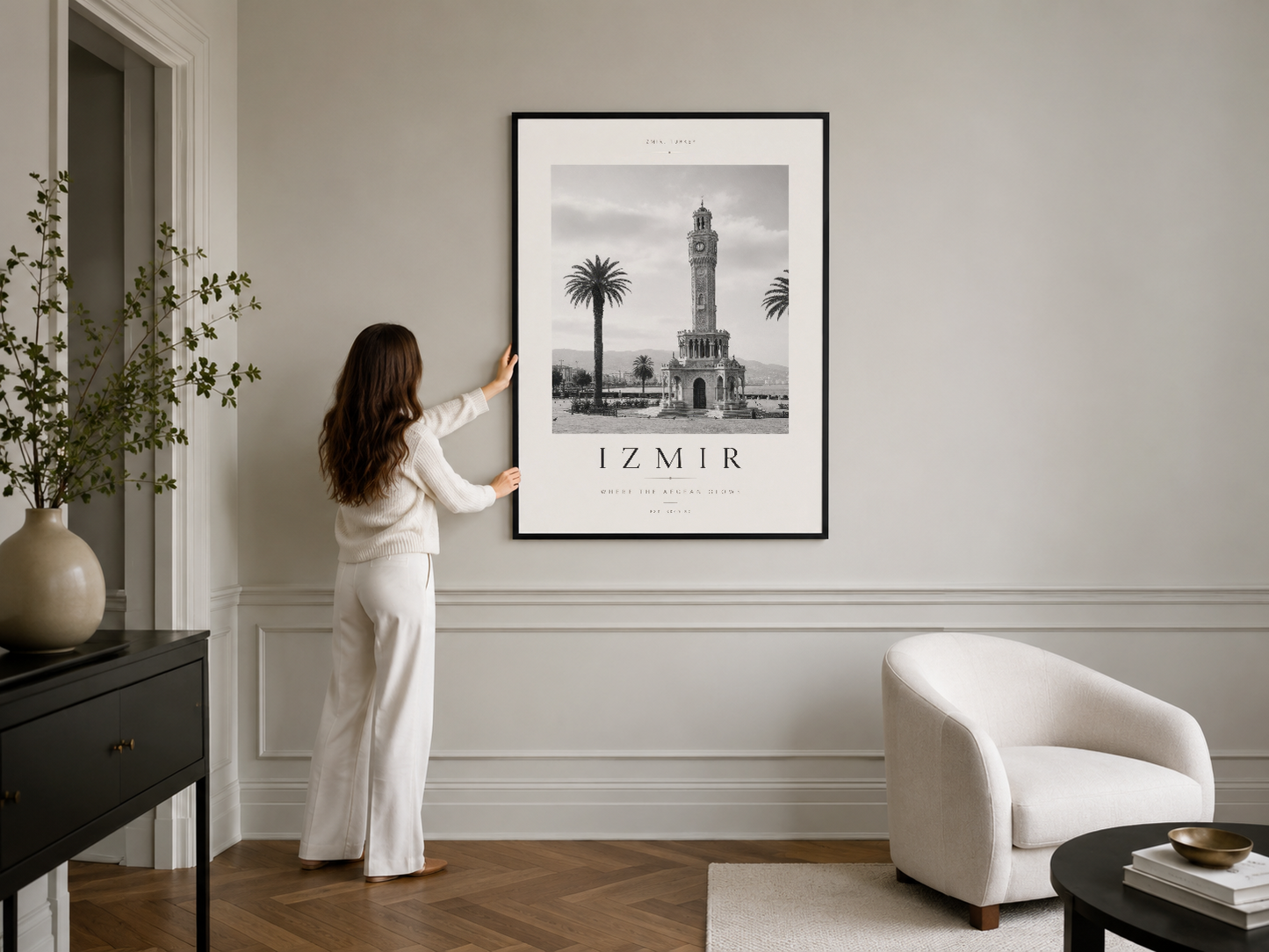 Beyaz duvardaki siyah çerçeveli poster, İzmir Saat Kulesi'nin zamanla yavaşlayan estetik görüntüsüyle minimalist dekorasyonu