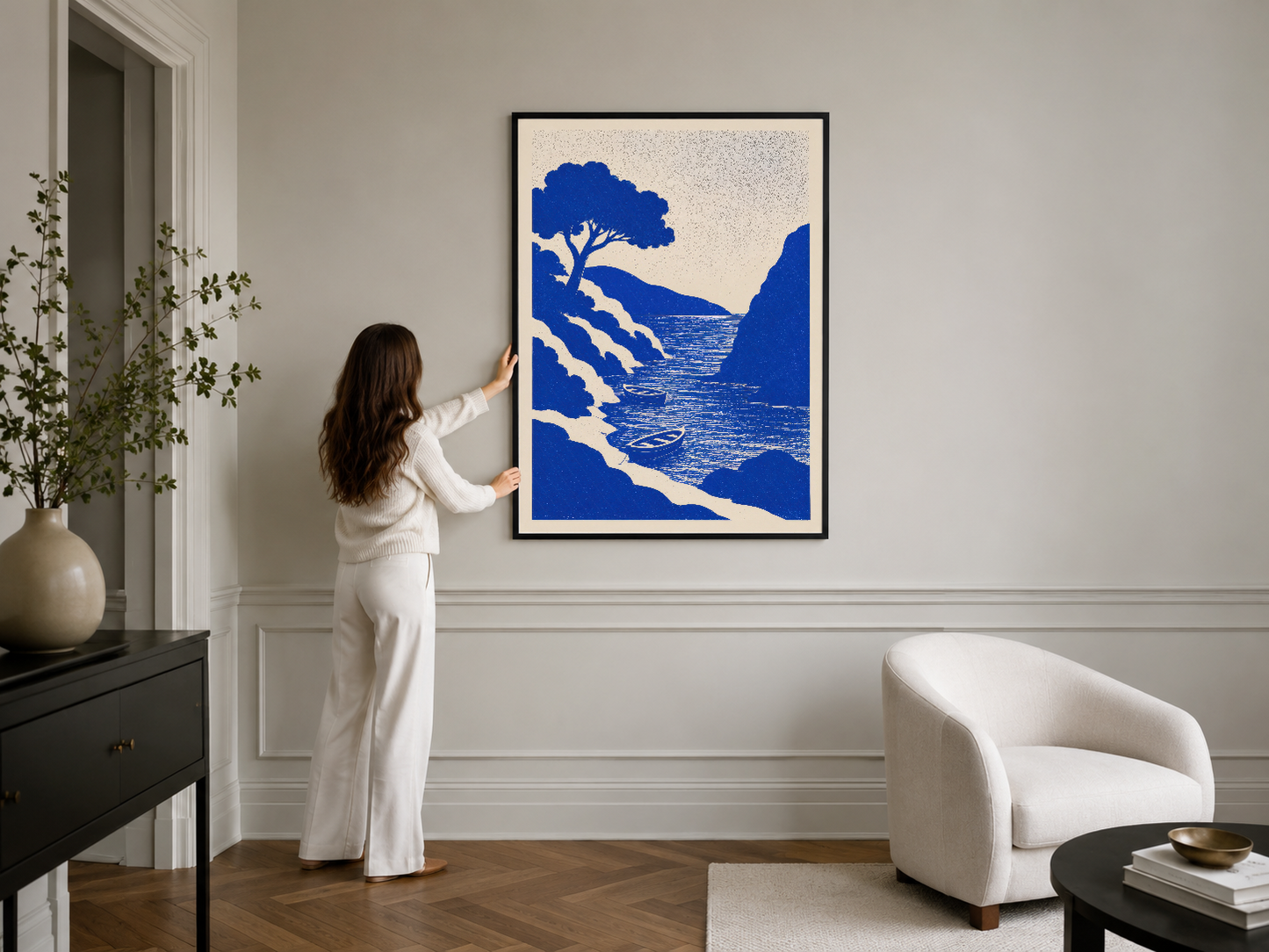 Siyah çerçeveli sanat baskısı, klasik iç mimaride kanepenin üstünde asılı mavi renk deniz sahnesi.