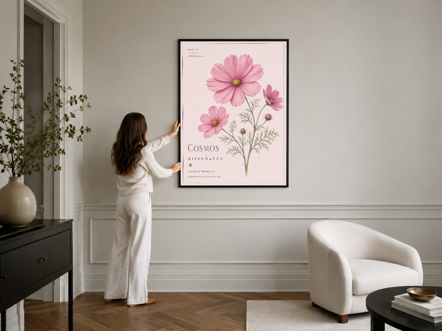 Pembe çiçek motifli duvar tablosu, siyah çerçeve içinde minimalist iç dekorasyon.