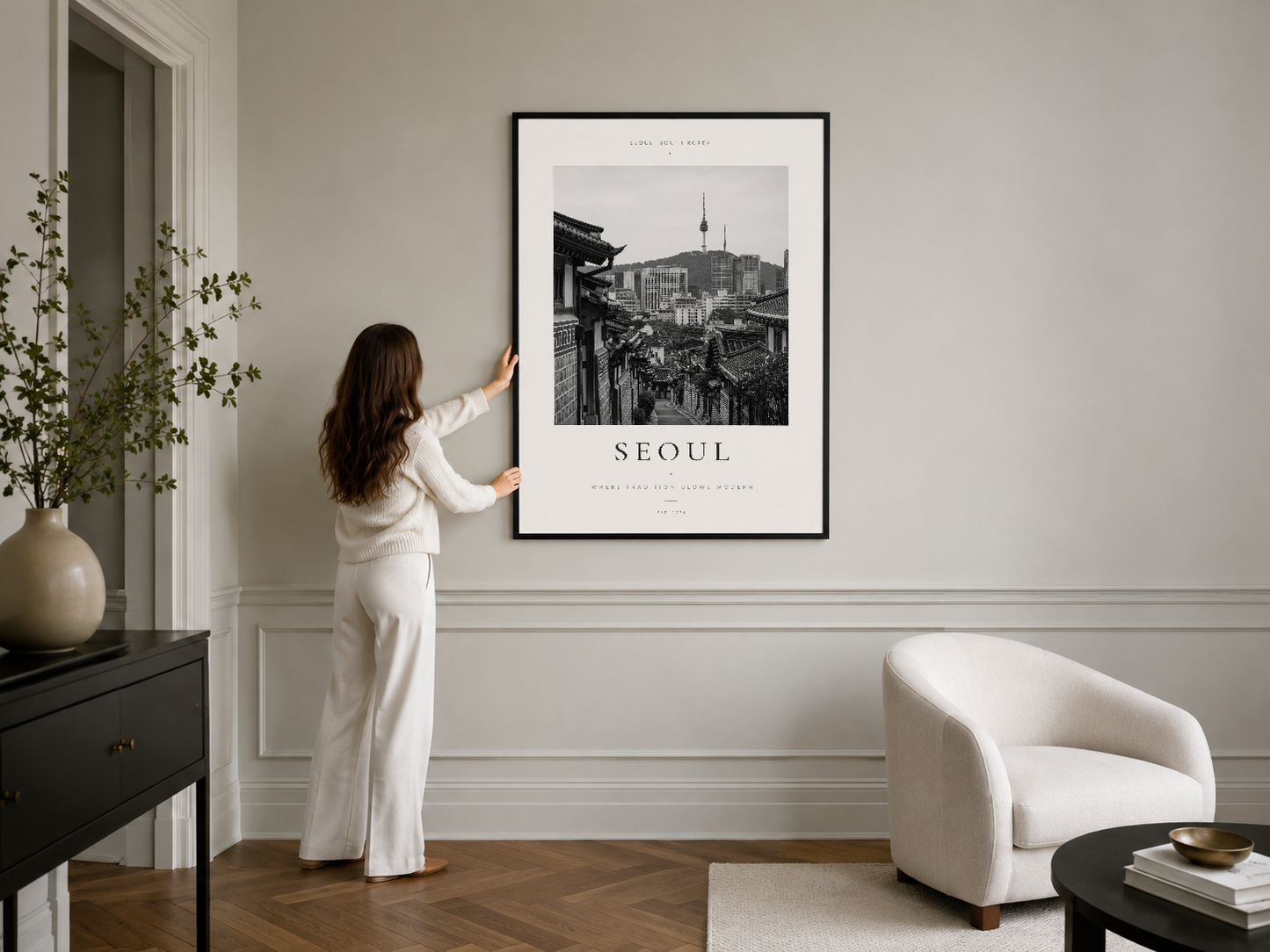 Şik Seoul poster, siyah çerçevede, modern minimalist yaşam alanında duvar panelinin üzerinde asılı.