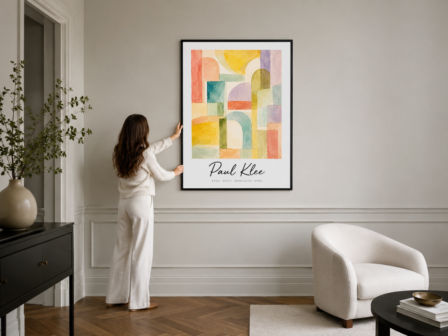 Paul Klee posterinin siyah çerçeveli versiyonu, minimalist salon dekorasyonunda sergileniyor.