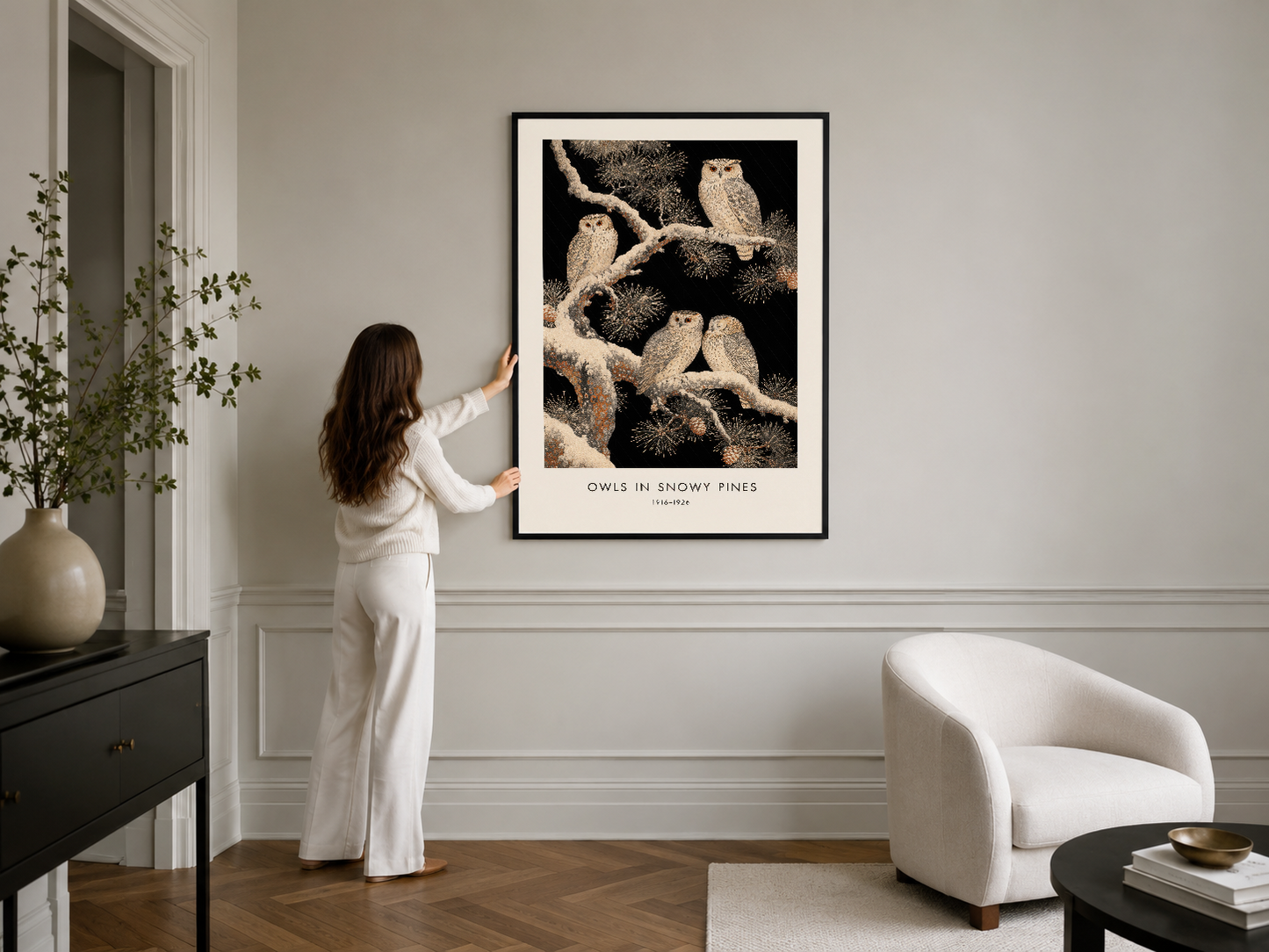Siyah çerçeveli doğa sanat tablosu, modern minimaliz oturma odasında beyaz duvar panelinin üzerinde konumlandırılmış.