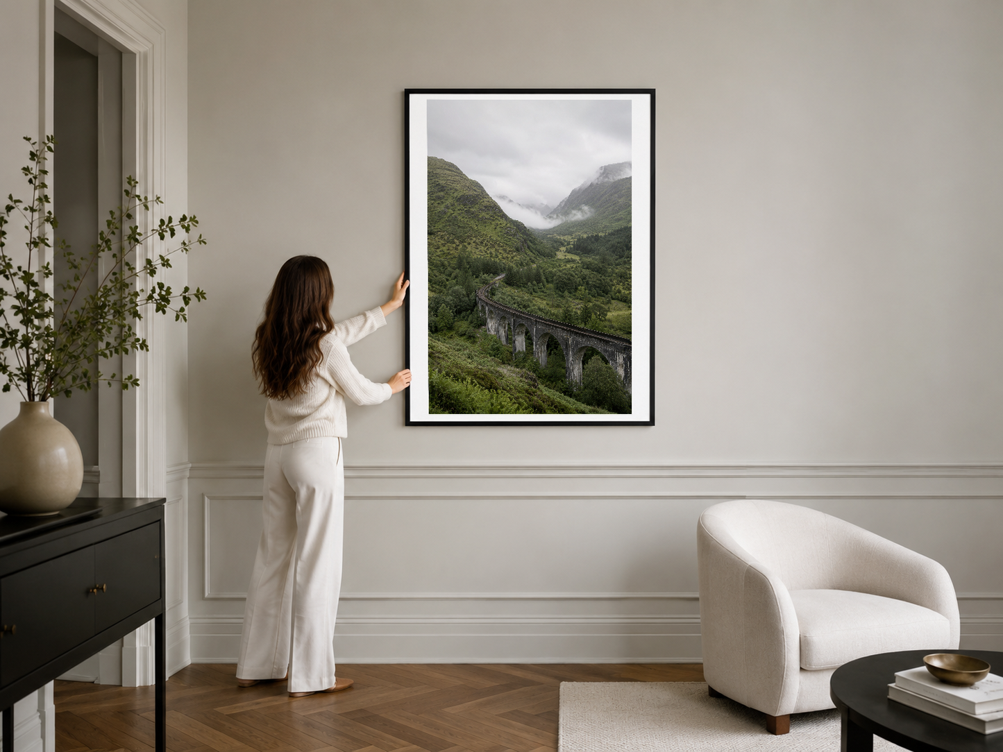 Siyah çerçeveli doğa fotoğrafı, klasik beyaz duvarı olan oturma odasında şık minimalist aksan oluşturuyor.