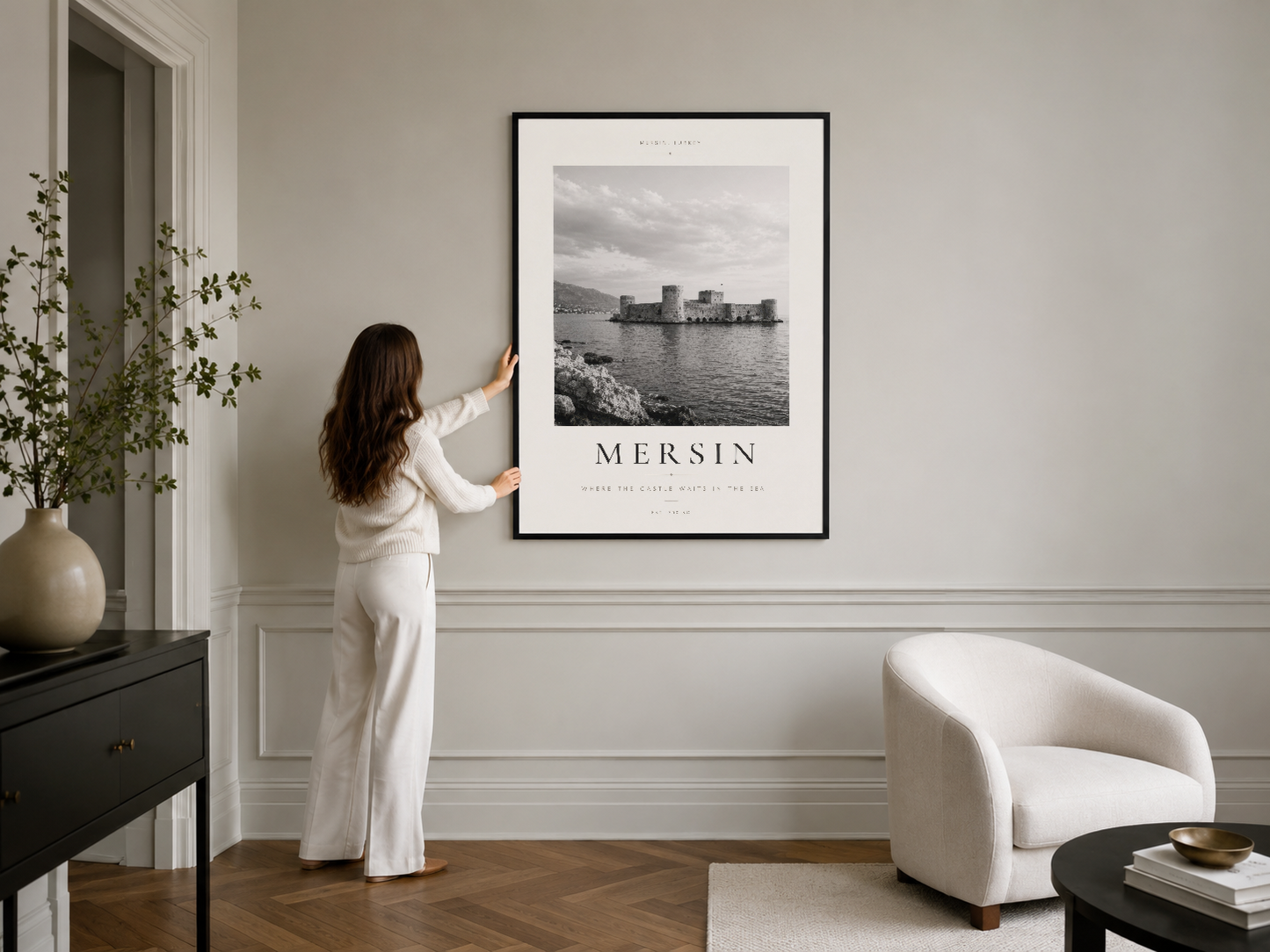 Mersin kalesi siyah-beyaz fotoğrafının şık siyah çerçevesiyle modern oturma odasının beyaz duvarında gösterilmesi.