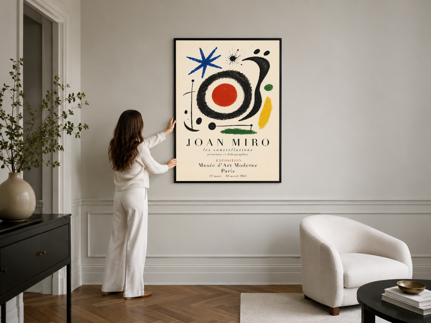 Joan Miro'nun renkli soyut eseri, şık siyah çerçevede, beyaz modern oturma odasını sanatsal bir merkez haline getirir.
