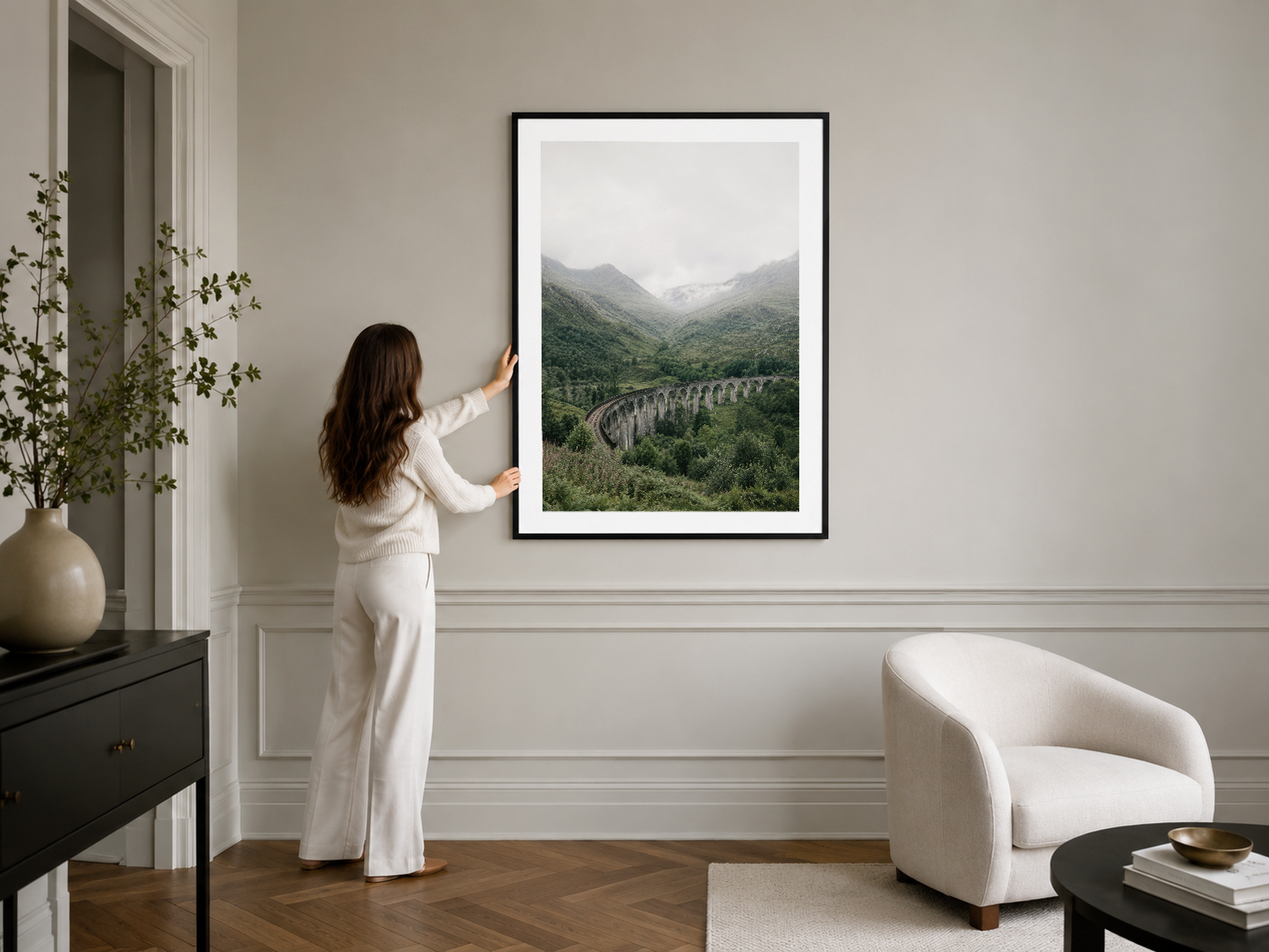 Dağ manzarasını gösteren yeşil fotoğraf, siyah çerçeve içinde, modern yaşam alanının ana dekoratif parçası konumunda.