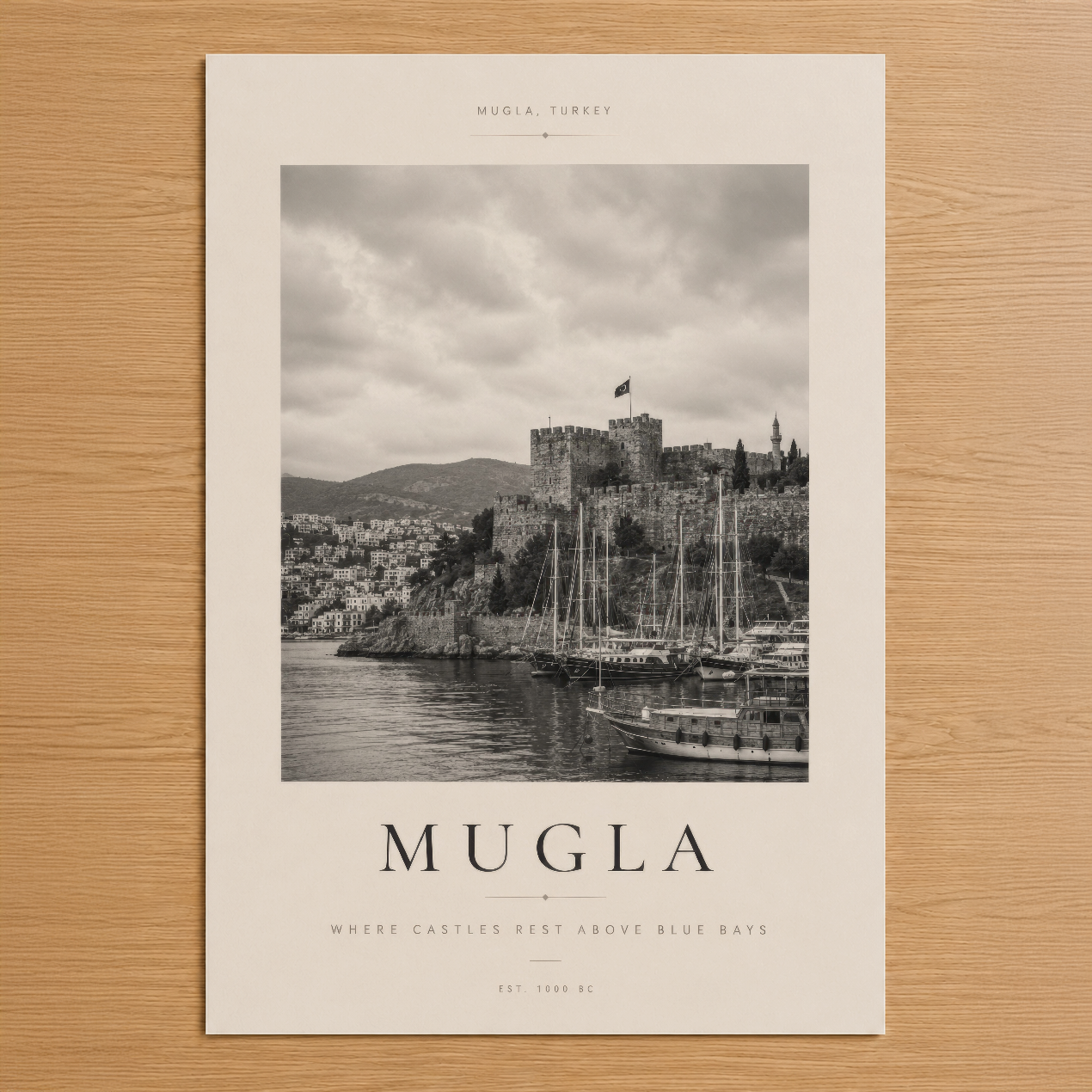Muğla'nın tarihi kalesini ve yelkenli tekneleriyle gösteren siyah beyaz poster, deniz ve dağ manzarasıyla.