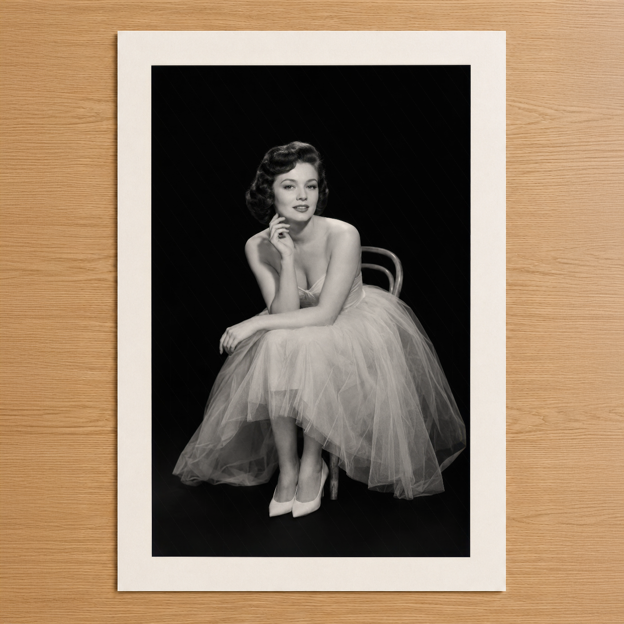 1950'ler Hollywood tarzında, siyah zemin üzerinde zarif tulle eteğiyle oturan kadın portresi siyah-beyaz poster baskı.