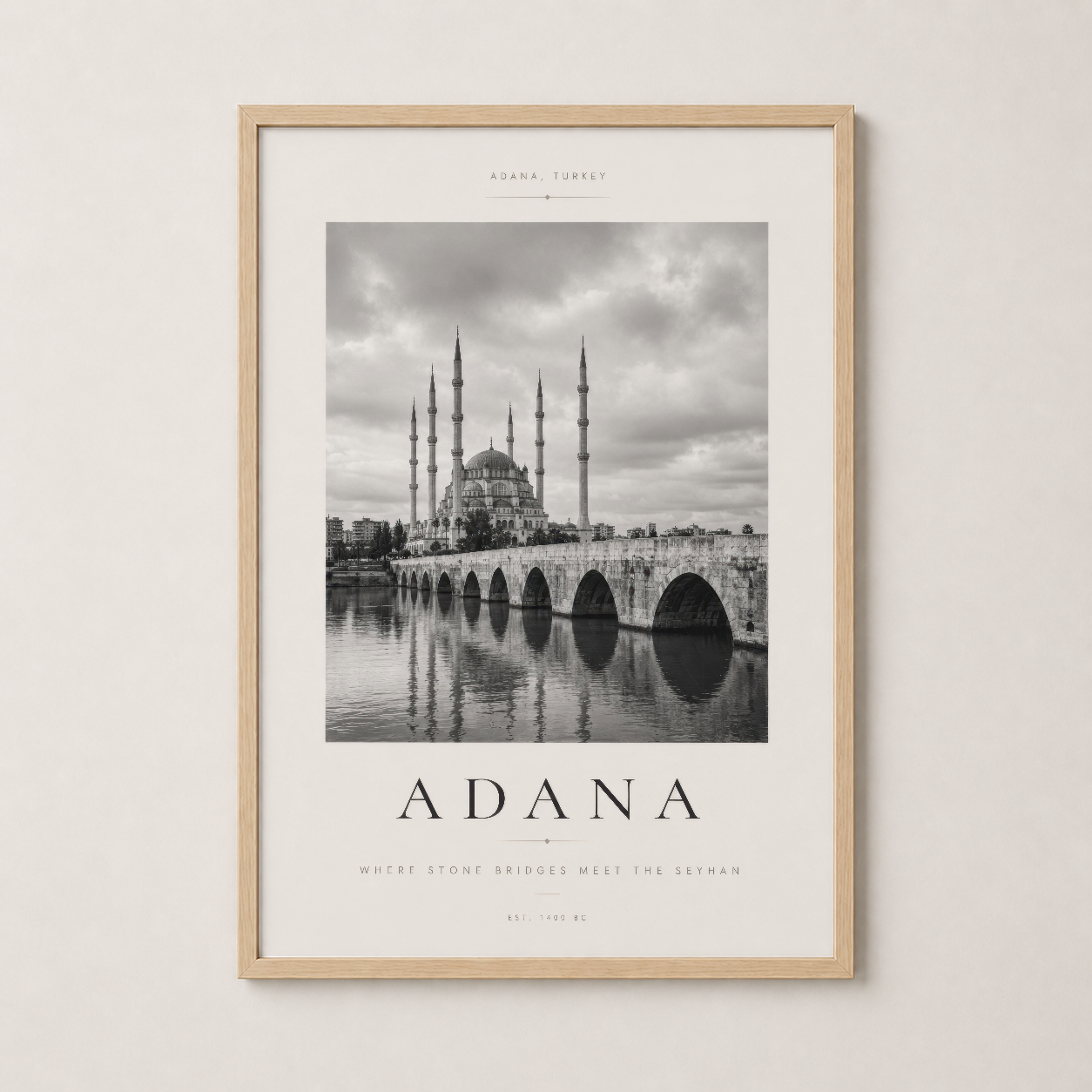 Doğal ahşap çerçeveyle çerçevelenmiş, Adana'nın mimari güzelliğini vurgulayan siyah beyaz sanat baskısı.