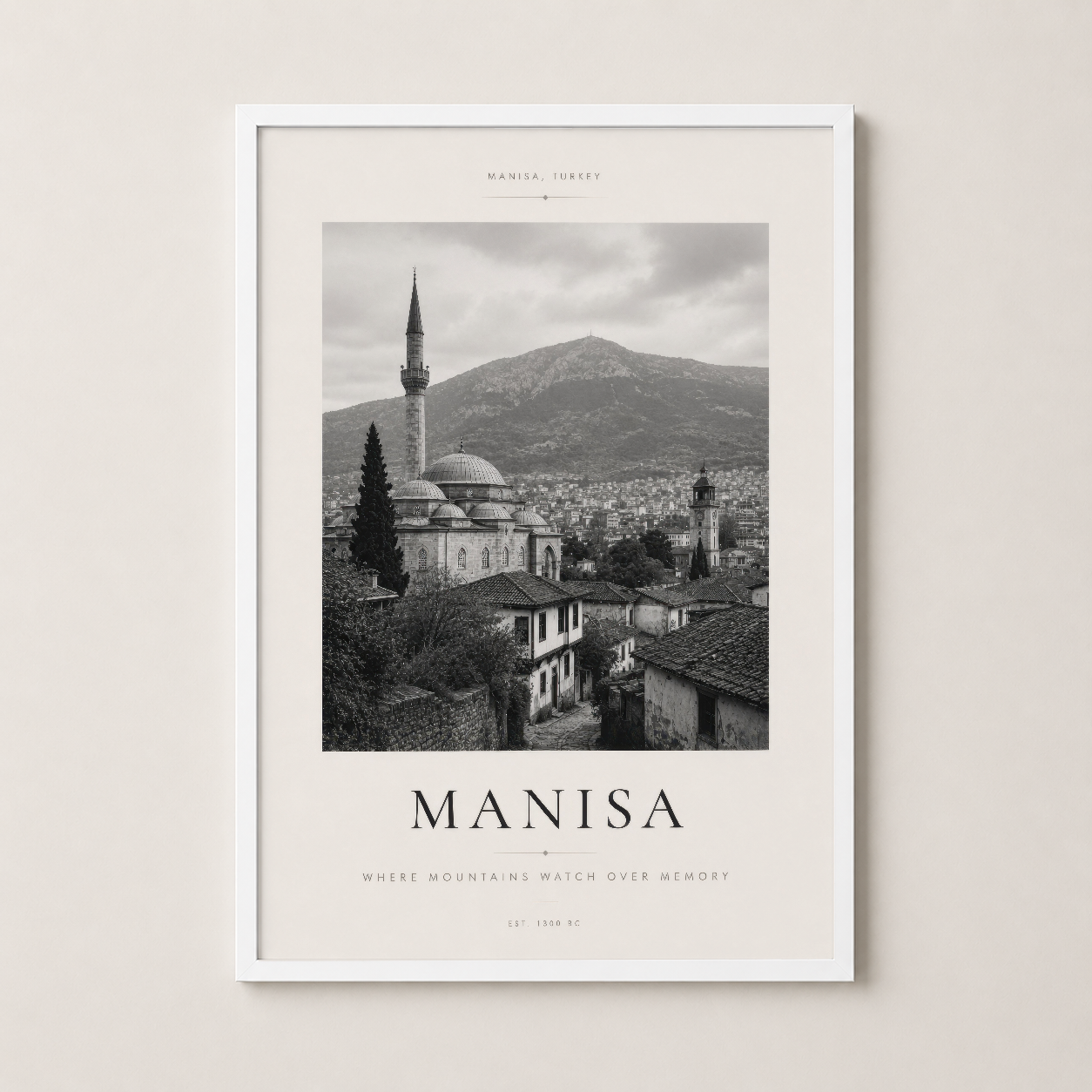 Dağlar ve tarihi yapıları gösteren Manisa posterinin beyaz çerçeveli dekoratif versiyonu.