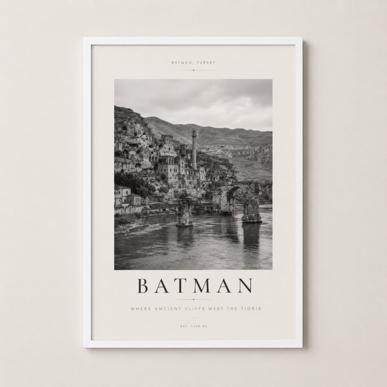 Batman poster beyaz çerçevede, antik kaya mimarisi ve nehir manzarasının minimalist tasarımı