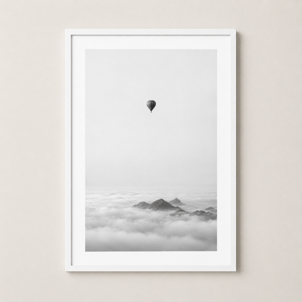 Beyaz çerçeveli, bulut denizinin üzerinde dağlar ve uçan bir balonun yer aldığı minimalist, huzurlu siyah beyaz fotoğraf