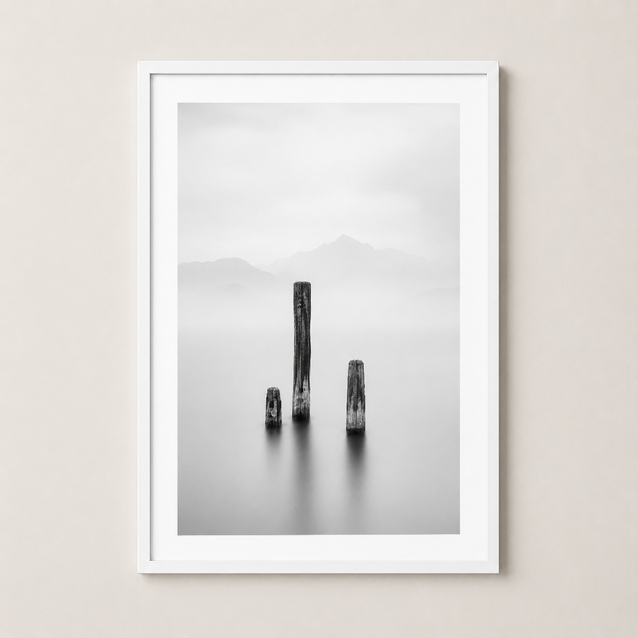 Beyaz çerçeveli sanat tablosu, minimalist estetik, gri tonlarda mistik doğa manzarası ve kütük kompozisyonu.