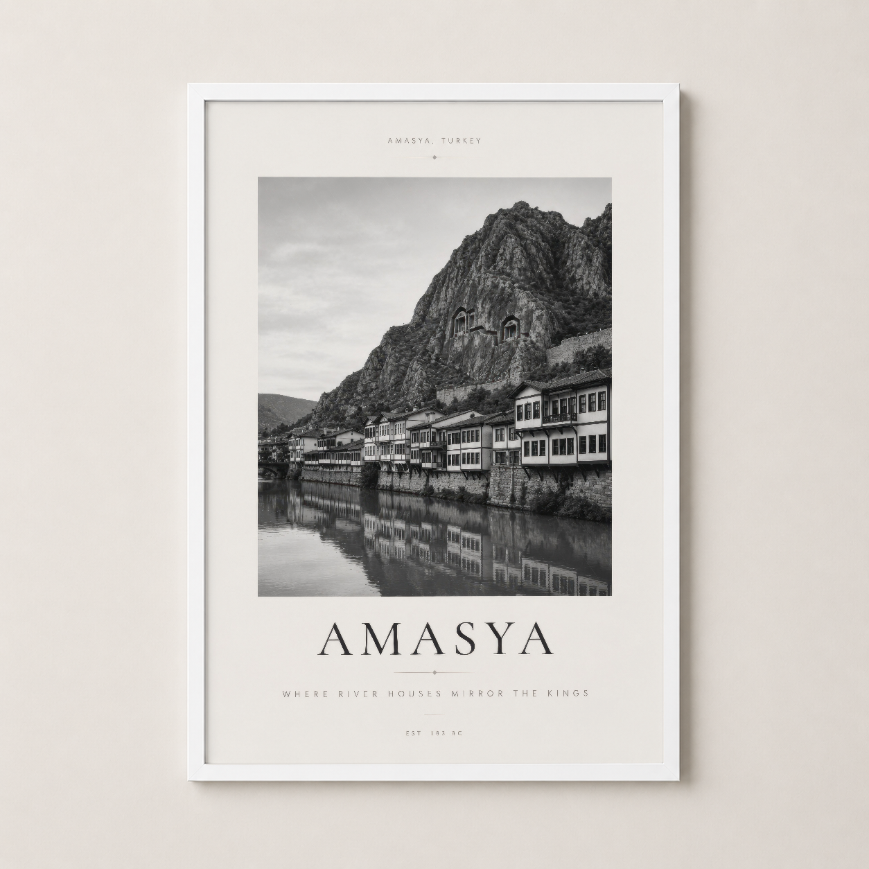 Beyaz çerçeveli Amasya sanat baskısı, dağlar ve antik yapılar içeren monokrom görüntüyle.