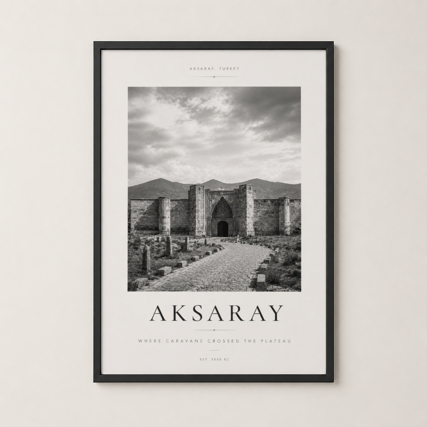 Aksaray tablosu siyah çerçevede, taş yapı ve antik yol detayları, sakin ve dekoratif atmosfer.
