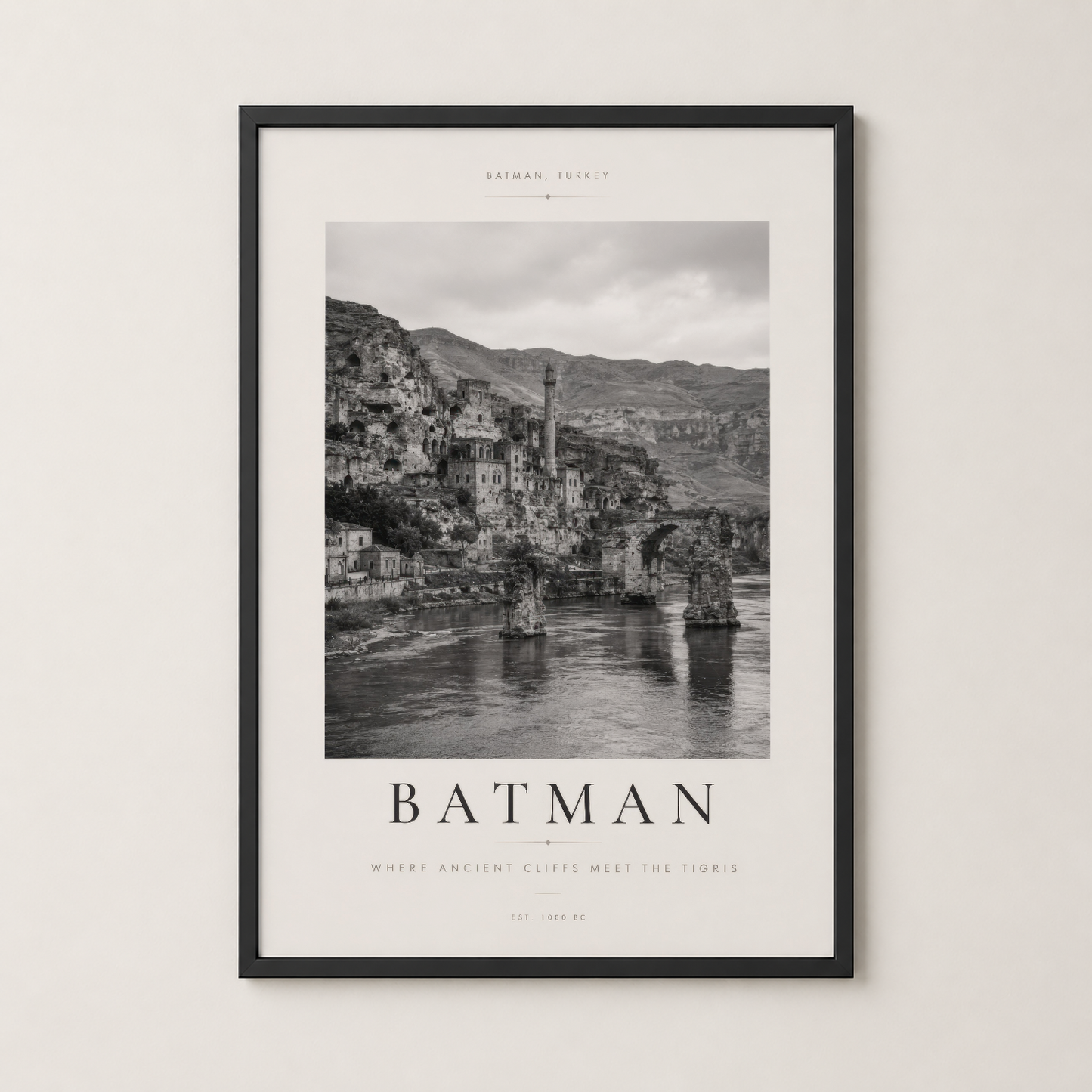 Batman poster siyah çerçevede, Tigris kıyısındaki tarihi yapıların dramatik siyah beyaz görüntüsü