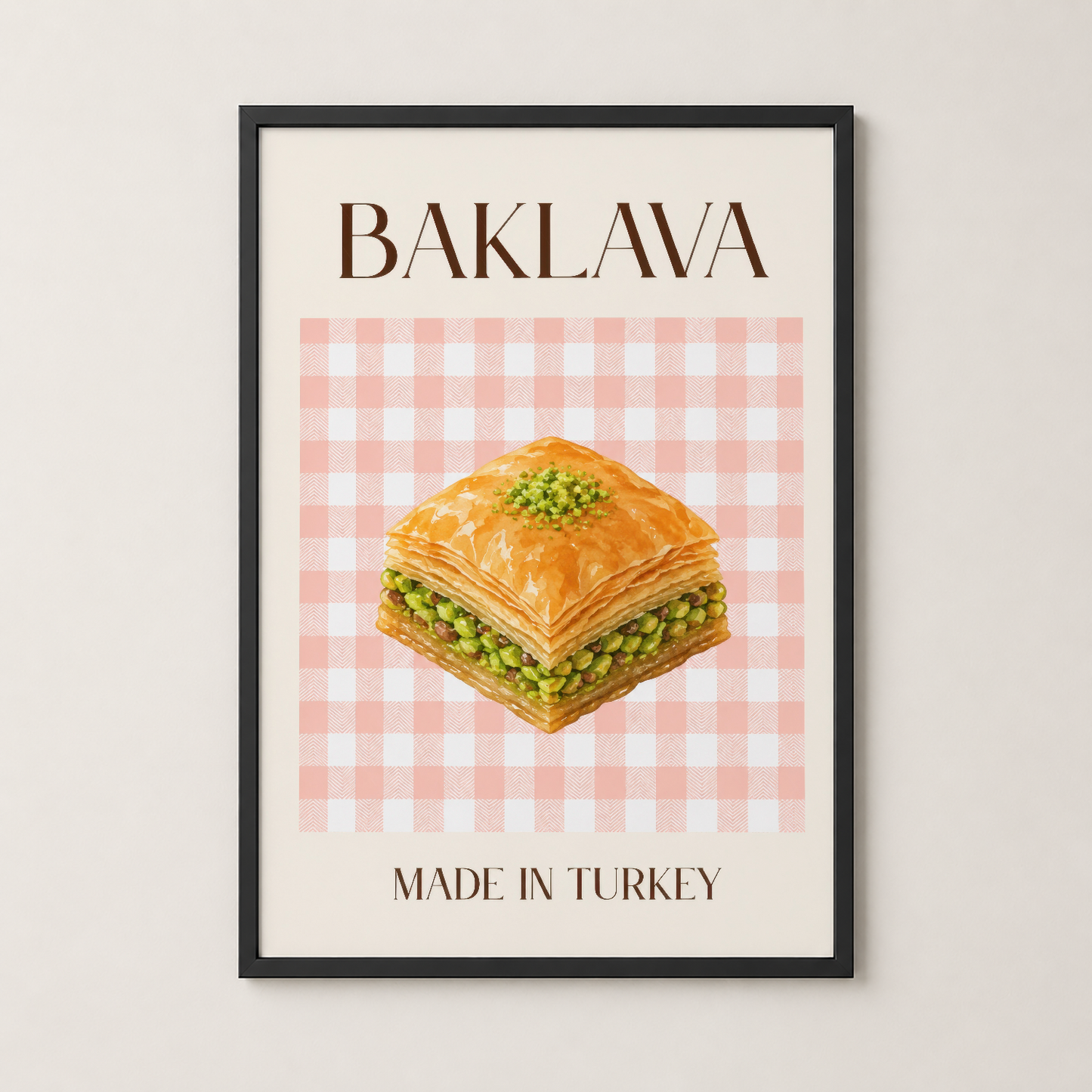 Baklava sanat tablosu siyah çerçevede, pembe ekose arka plan ve yeşil fıstıklı tatlı tasarımı ile modern dekor.