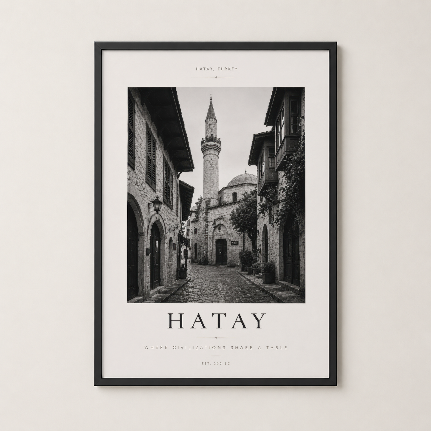 Hatay Türkiye posteri siyah çerçevede, antik sokaklar ve minareyi içeren minimalist tasarım.