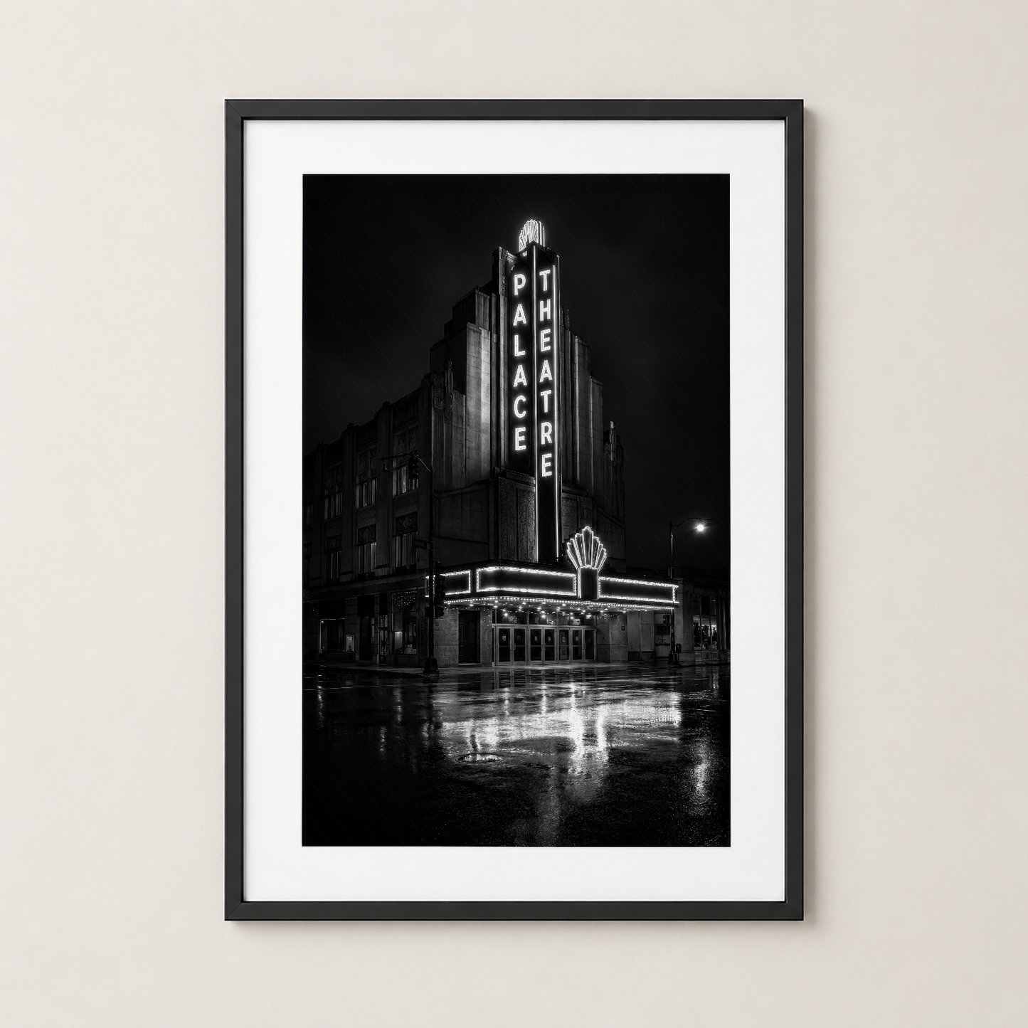 Siyah çerçeveli duvar tablosu: ikonik Palace Theatre neon işaretleri, yağmur vurmuş sokaklar ve nostaljik Art Deco mimarisi.