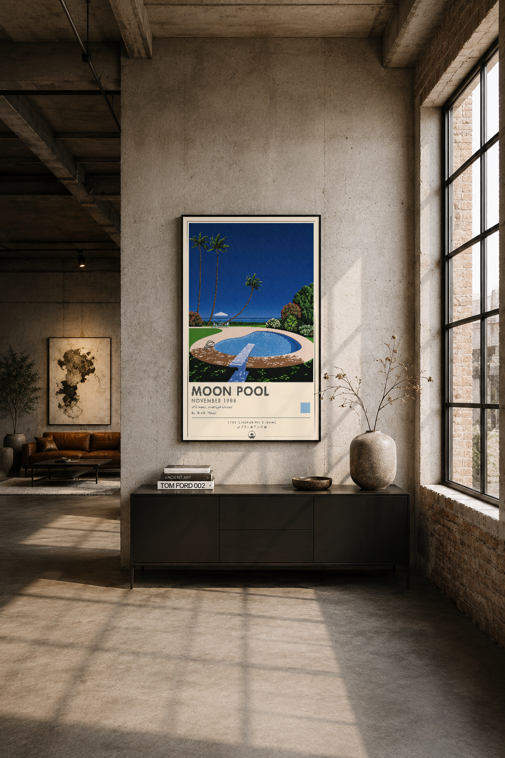 Modern endüstriyel stüdyoda, beyaz duvar üzerinde siyah çerçeveli Moon Pool tablosu asılı duruyor.