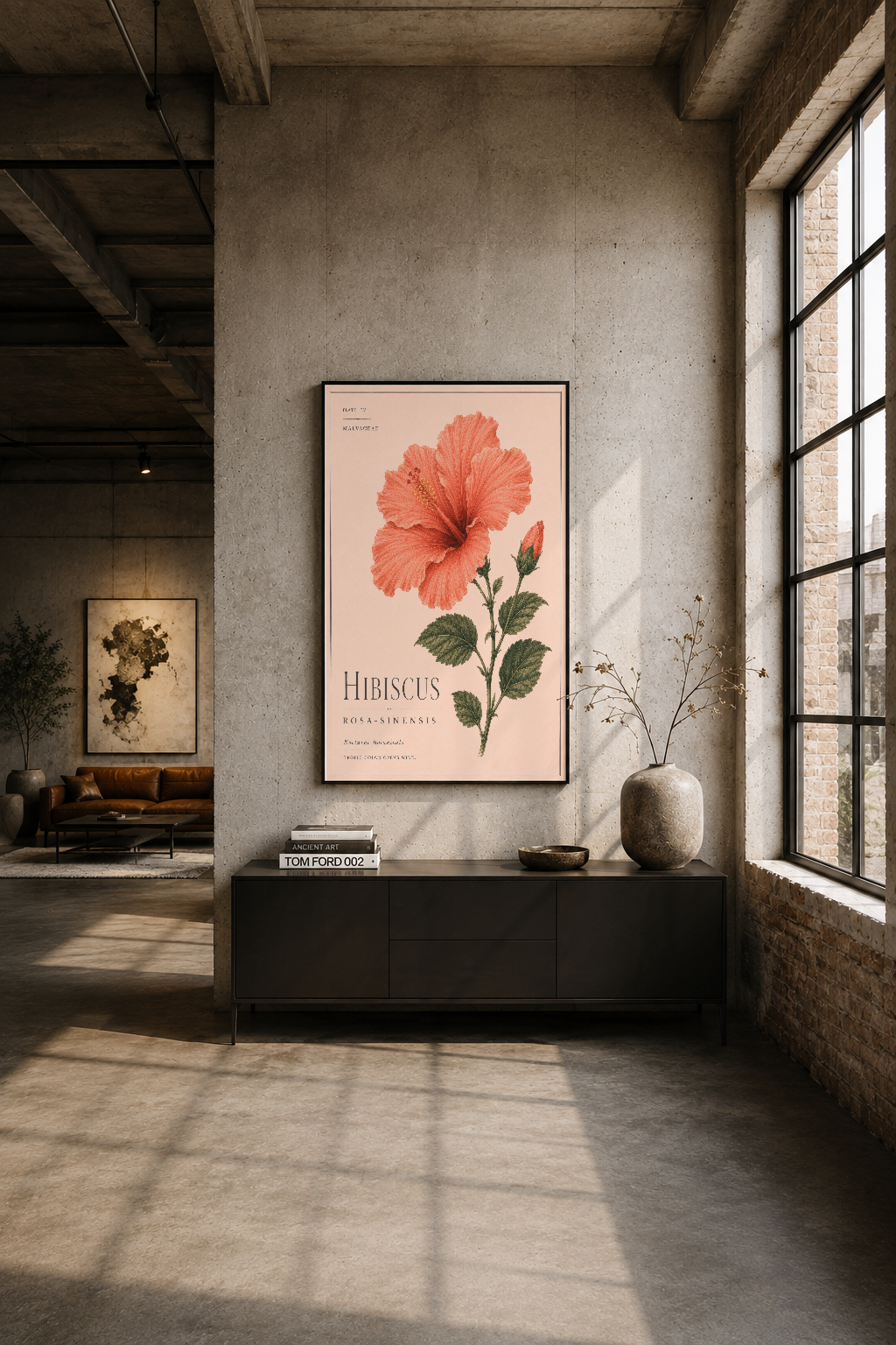 Modern loft oturma alanında, geniş duvar üzerinde siyah çerçeveli hibiskus tablosu, endüstriyel tasarımla kontrastlık