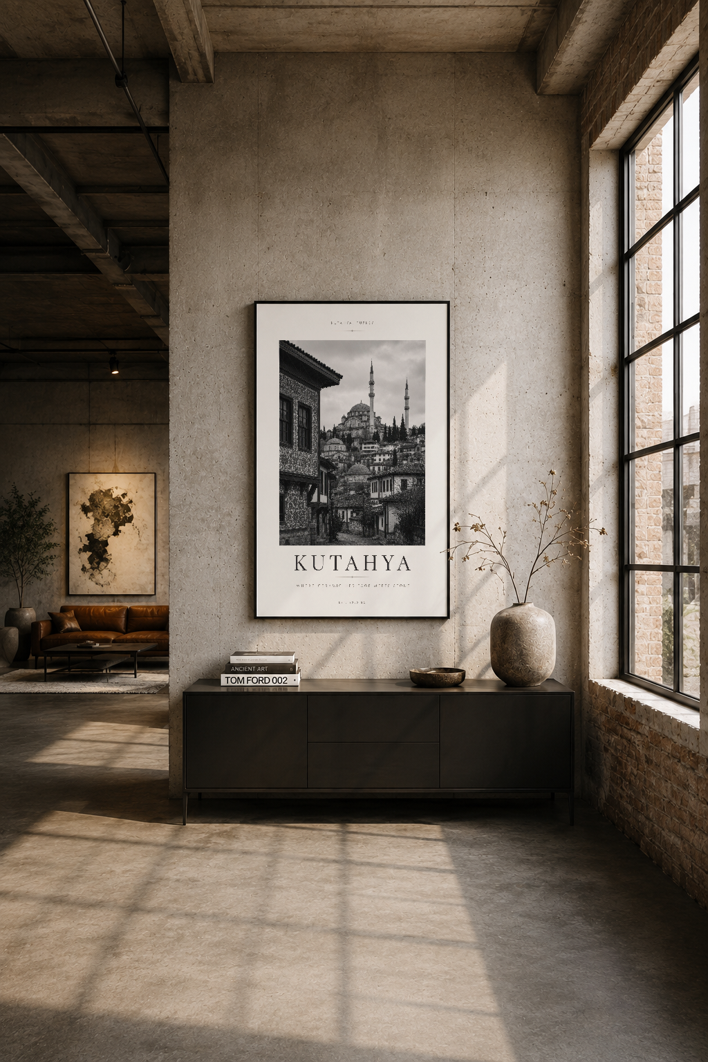 Endüstriyel loft oturma alanında duvar göz hizasında asılı, Kütahya siyah çerçeveli poster dekorasyonu.