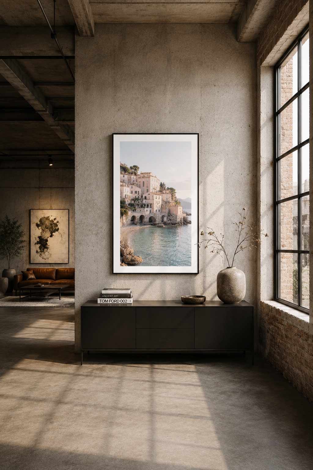 Modern endüstriyel loft'ta, siyah komid üzerine siyah çerçeveli Akdeniz manzara tablosu.