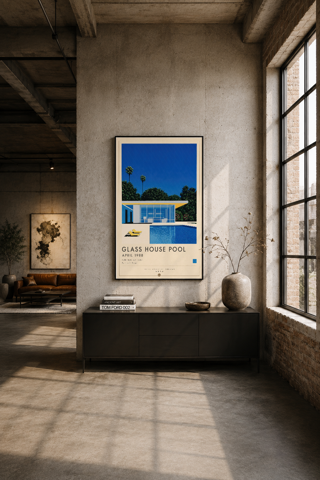 Endüstriyel tarzda, beton duvarlar ve geniş pencereler olan mekanın orta yerinde Glass House Pool posteri siyah çerçevede.
