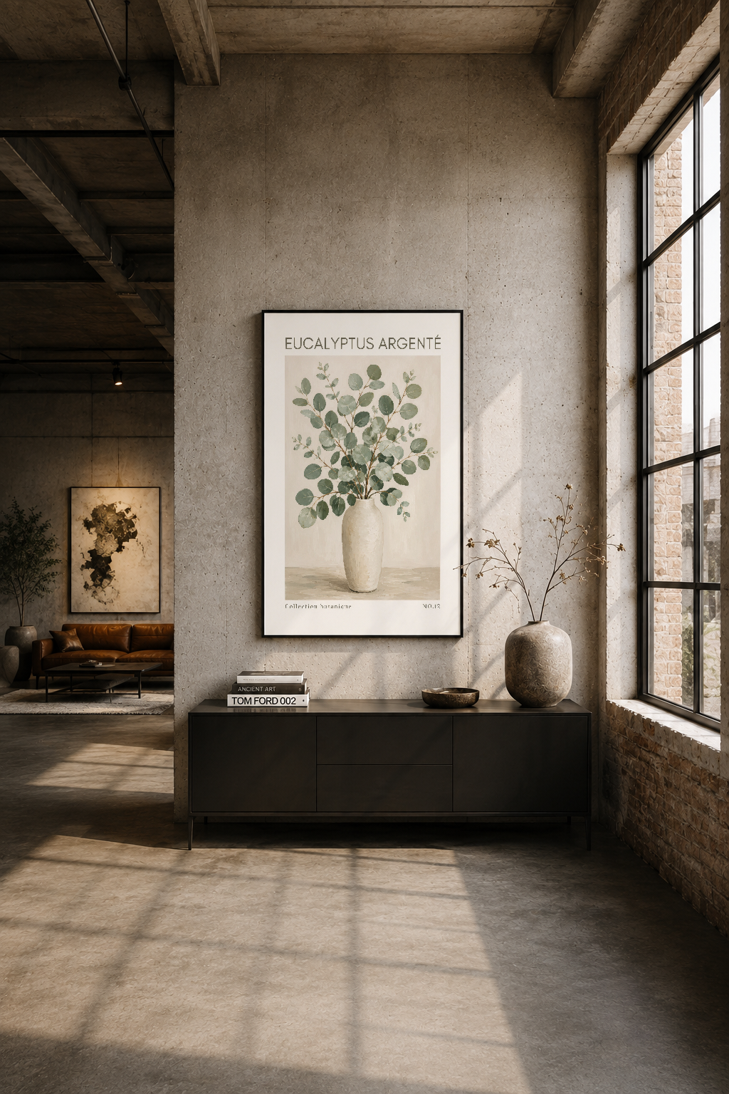 Endüstriyel loft oturma alanında siyah çerçeve içinde Eucalyptus Argenté tablosu sergileniyor
