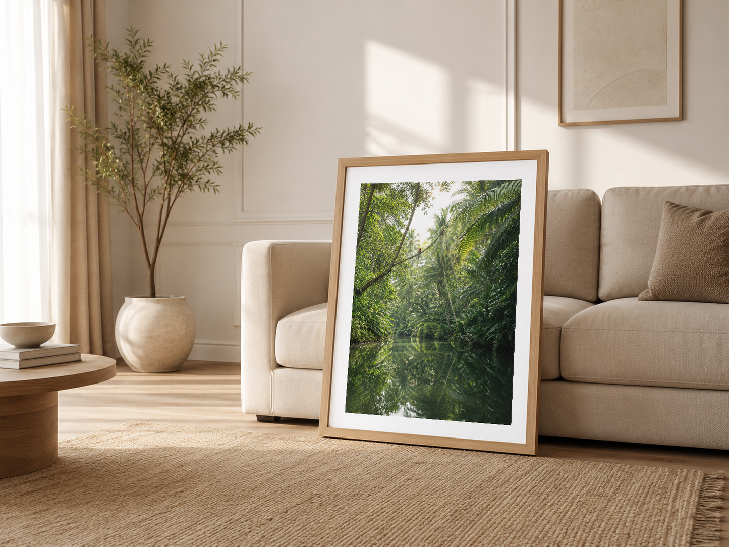 Açık oturma odasında ahşap çerçeveli orman tablosu, beige kanepenin yanında propped pozisyonunda sergilenmiş.