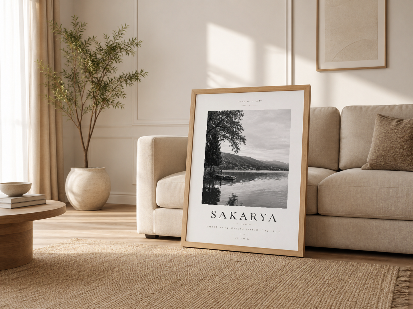 Sakarya poster ahşap çerçeveli, krem renkli living room'da kanepenin yanında rahatça sergileniyor.