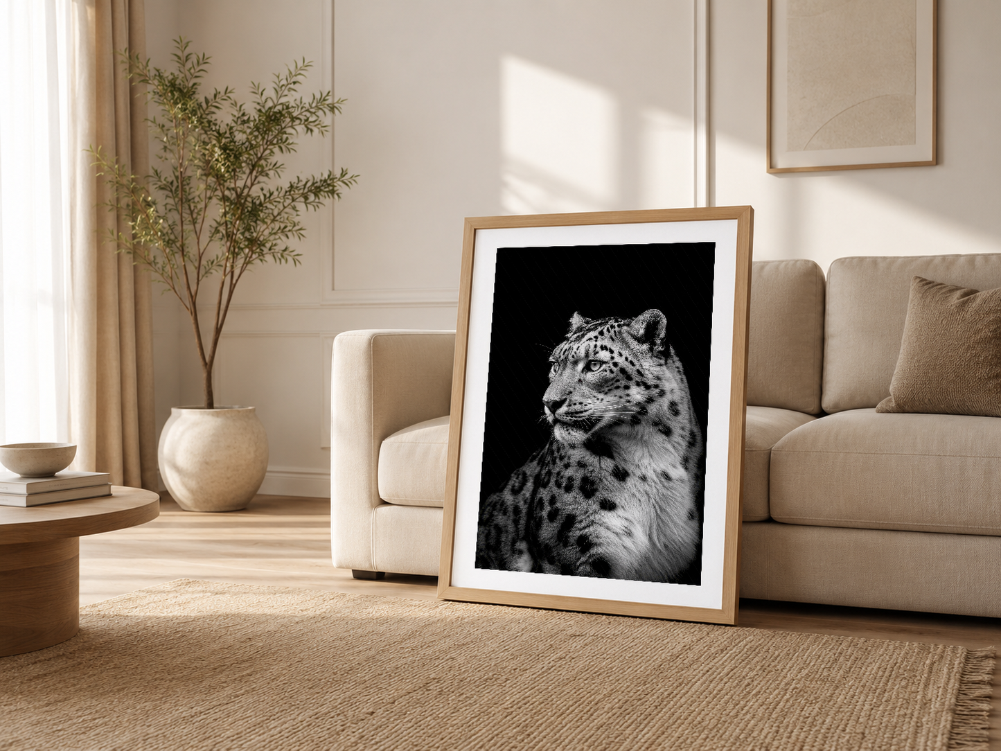 Modern oturma odasında krem renkli çerçeveli kar leoparı tablosu, kanepesi yanında güneşli atmosferde sergileniyor.