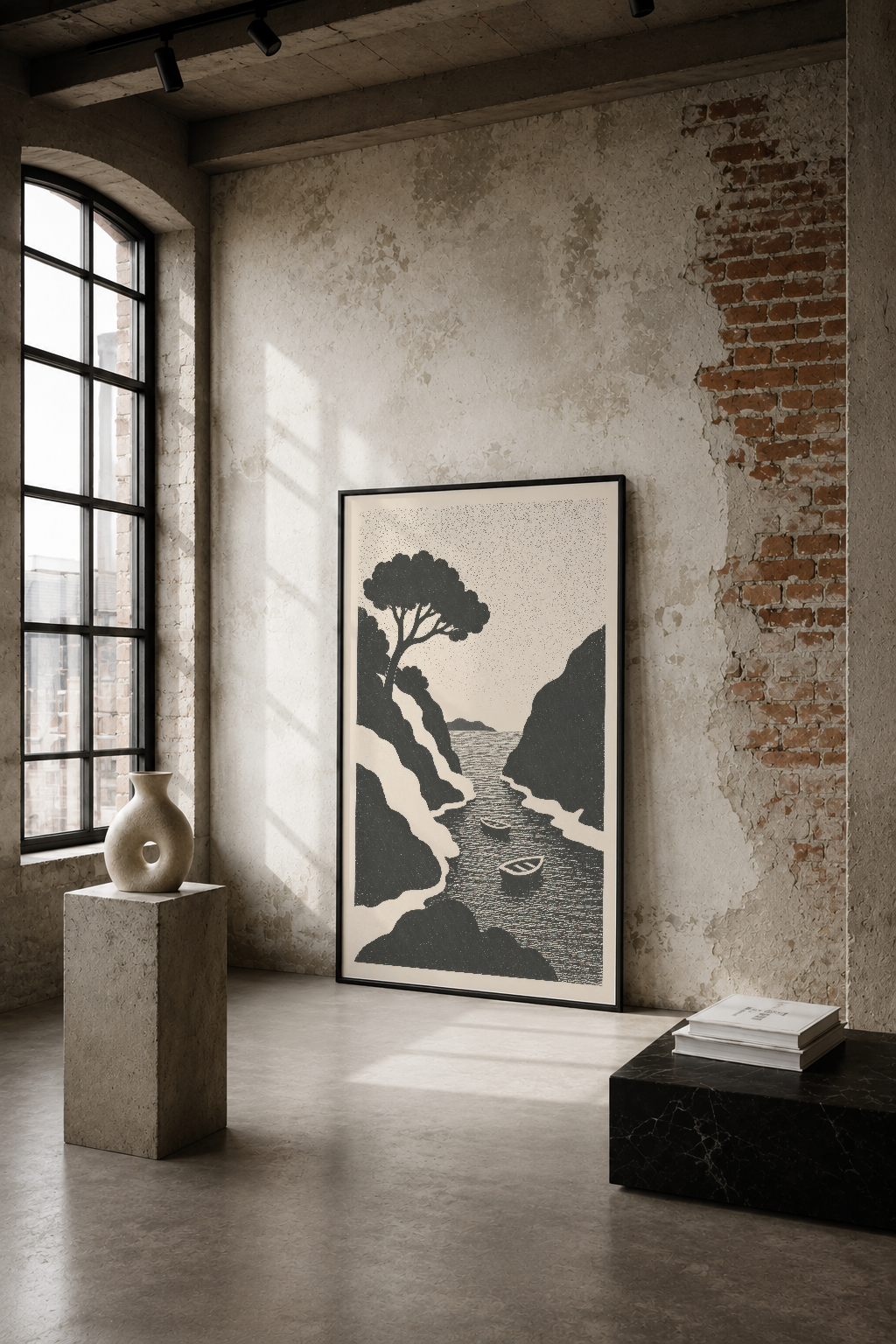 Minimalist endüstriyel mekanda siyah çerçeveli poster, deniz manzarası ve ağaç tasarımı sergileniyor.