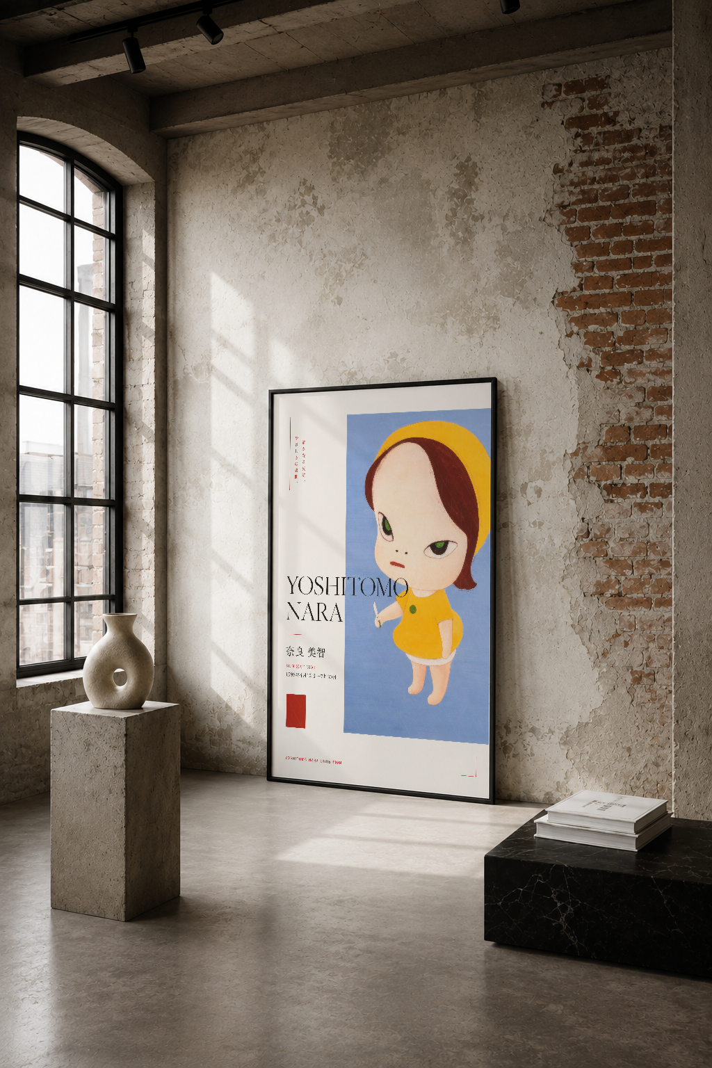Yoshitomo Nara sergisi posteri, endüstriyel bir mekanda duvarın üzerinde, minimalist tasarımı vurgulayan siyah çerçevede.
