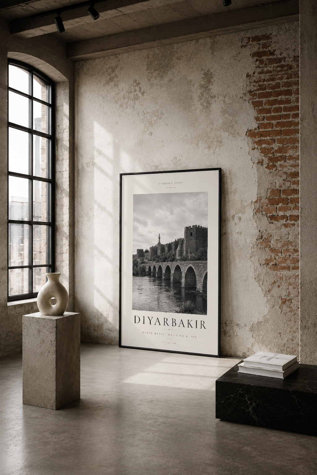 Diyarbakır'ın tarihi köprüsünü gösteren siyah beyaz poster, endüstriyel loft stiliyle dekore edilmiş mekânda asılı.